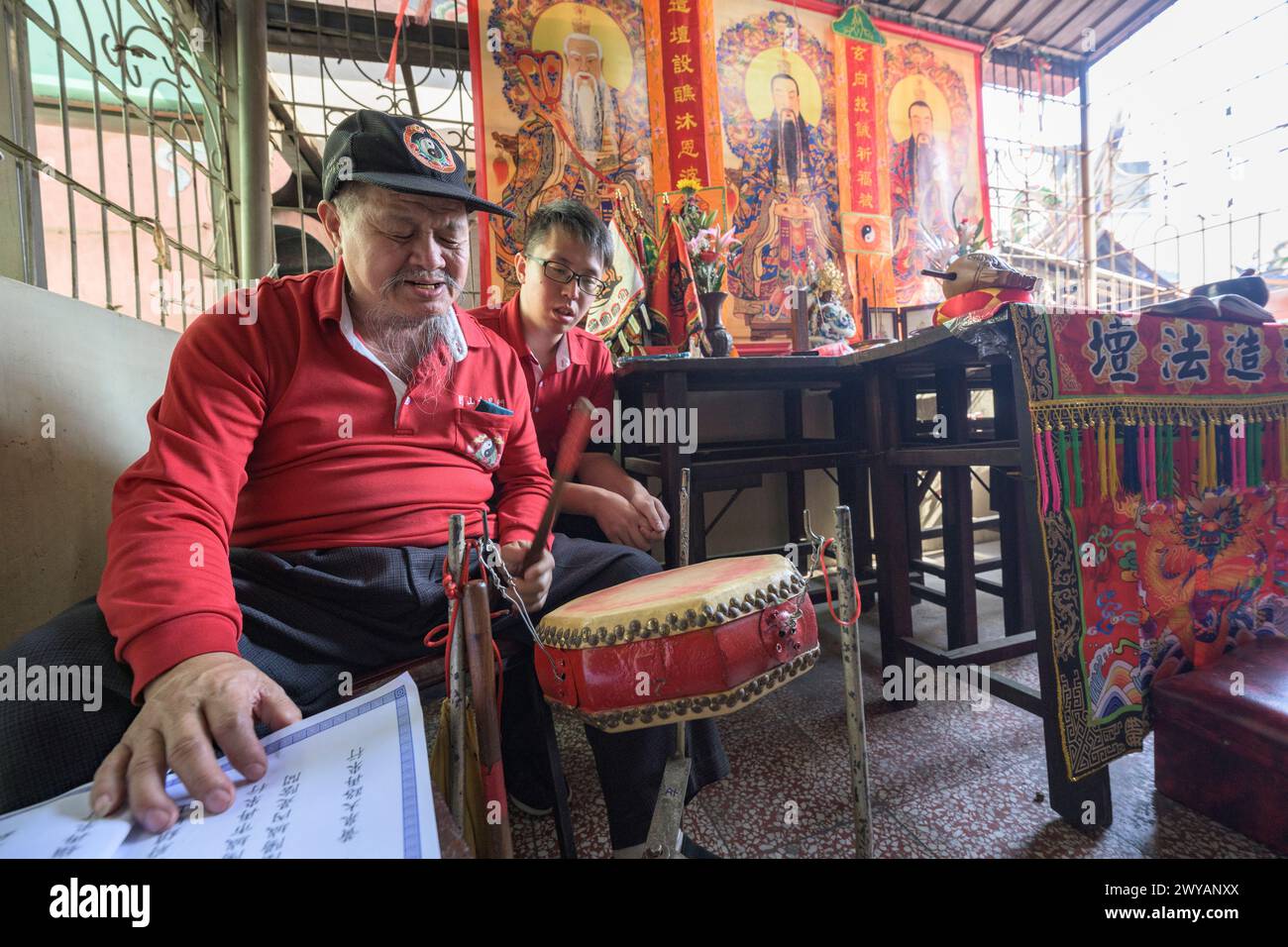 Participant senior jouant un tambour lors d'une cérémonie culturelle à l'intérieur du temple Dongyue Hall Banque D'Images