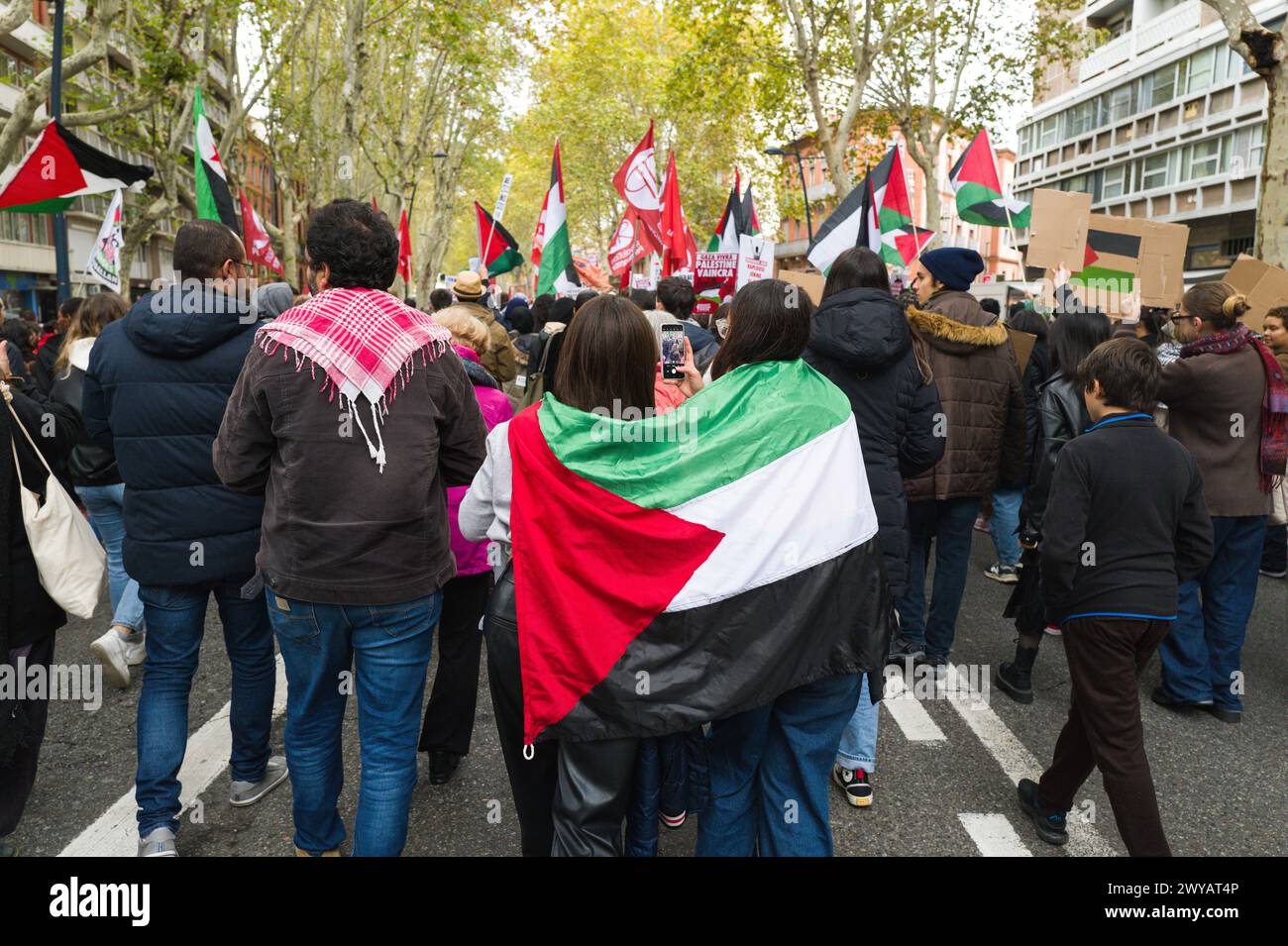 Deux jeunes femmes de derrière avec le drapeau palestinien dans leur cape. Manifestation pour la paix à Gaza, contre les massacres et les appels. Banque D'Images