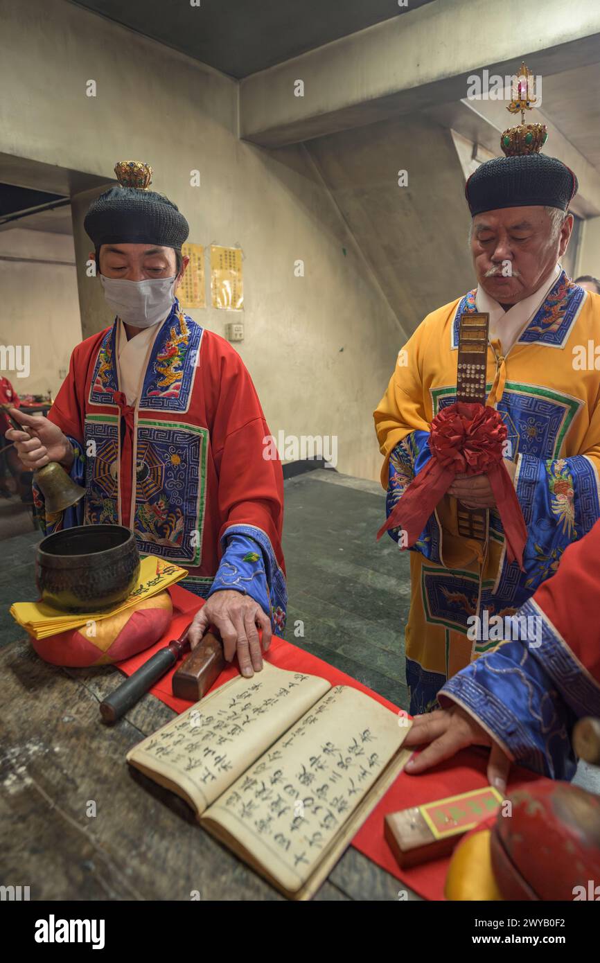 Un chaman traditionnel exécutant un rituel avec des offrandes aux ancêtres sur un autel dans le temple Donggyue Hall Banque D'Images