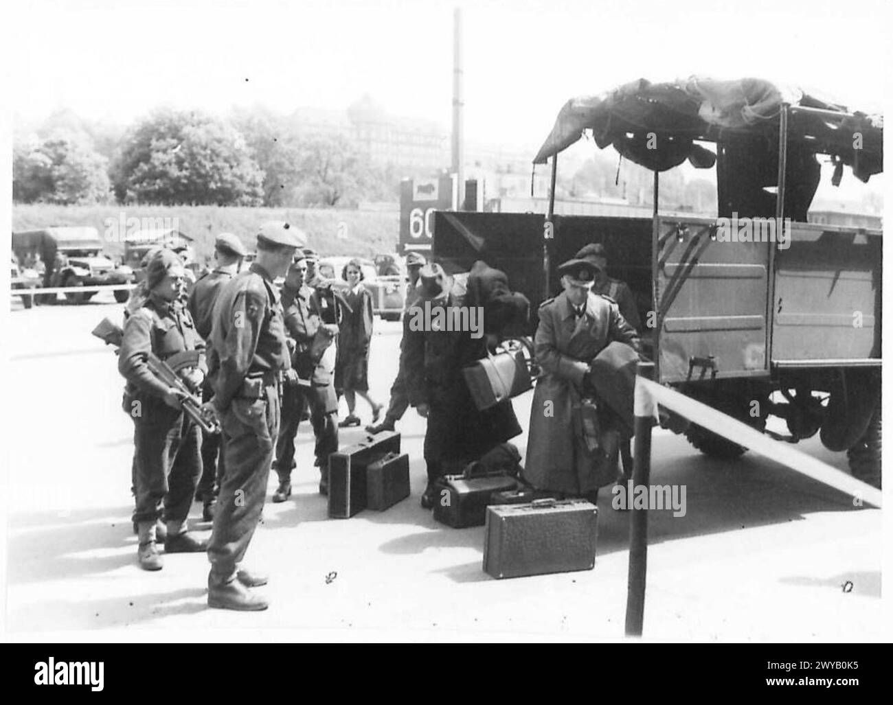 Des officiers et des fonctionnaires nazis arrivent avec des bagages au quartier général militaire britannique après des arrestations pendant les opérations de la seconde Guerre mondiale. Banque D'Images