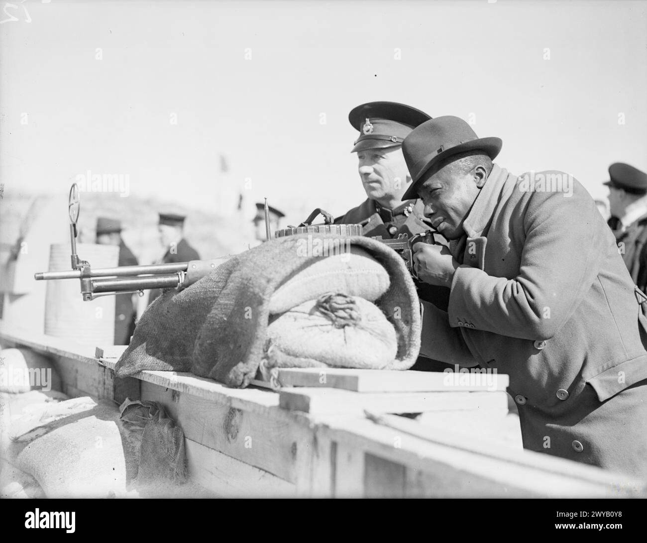 Le 1-2 avril 1942 à Liverpool, un marin des Antilles reçoit une instruction d'artillerie d'un instructeur de la Royal Marine à l'école de formation des marins marchands interalliés. Banque D'Images