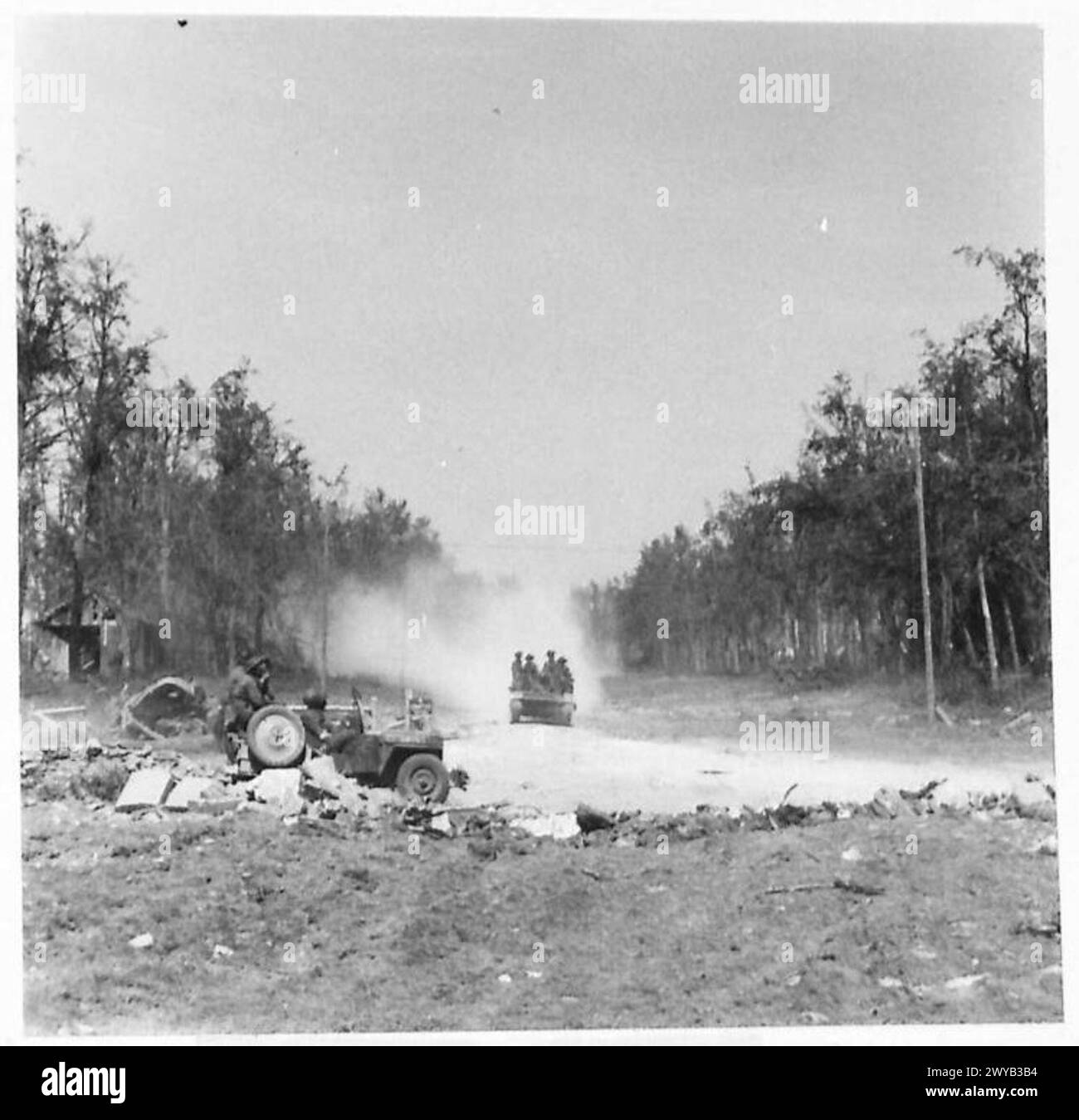 Le blindage avance le long d'une avenue détruite d'arbres menant au château de Garcelles-Secqueville. Les casernes allemandes situées en dessous ont été détruites par les opérations de la RAF. Documenté par l'armée britannique, 21e groupe d'armées. Banque D'Images