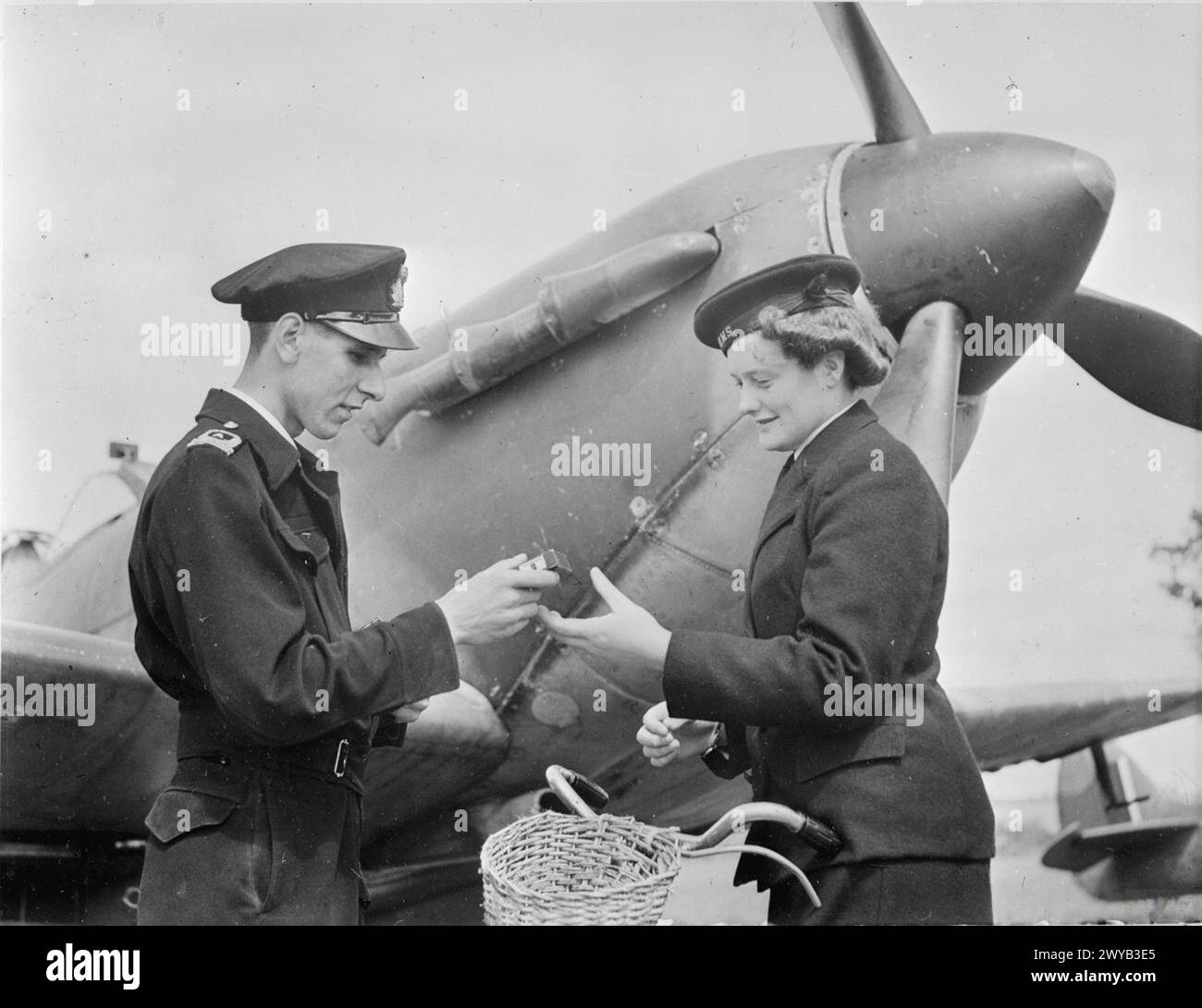 En août 1944, à bord du HMS Dipper à Henstridge, un pilote remet le chargeur de film G45 à un messager du WRNS pour livraison à la section photographique de la station. Banque D'Images
