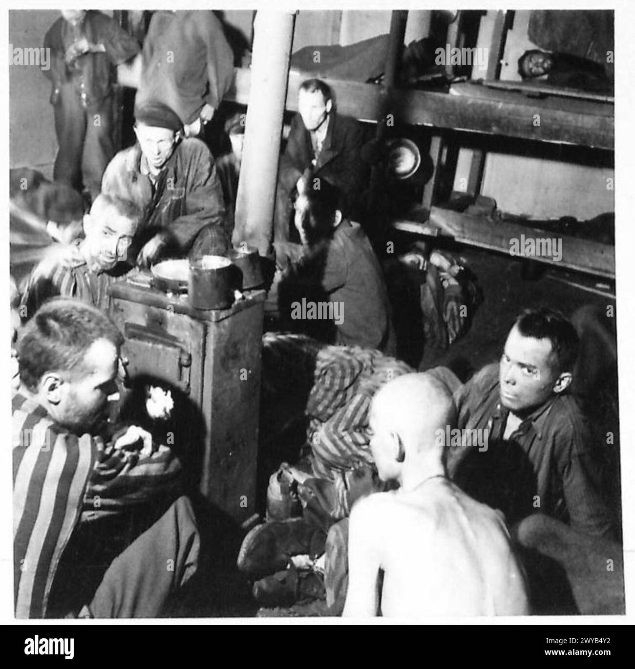 En 1944-1946, les habitants du Nord-Ouest de l'Europe vivent dans des conditions sordides alors que le personnel de l'armée britannique est présent. La photographie montre des morts et d'autres assis près d'un feu. Documenté par le 21e Groupe d'armées. Banque D'Images