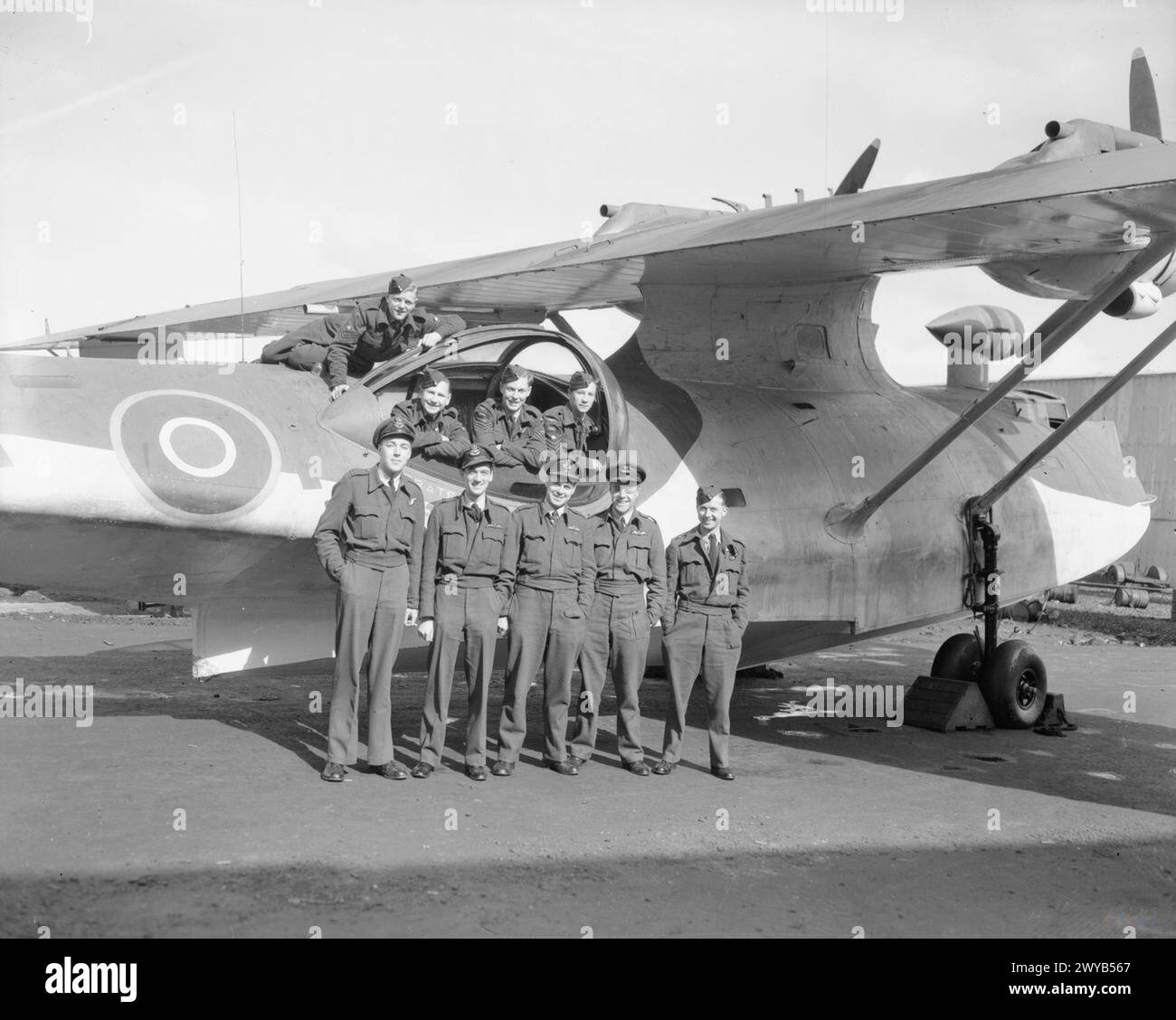 ROYAL AIR FORCE COASTAL COMMAND, 1939-1945. - L'équipage du Consolidated Catalina Mark IV 'X' du No. 210 Squadron RAF, qui a fait la dernière attaque de la guerre sur un sous-marin allemand, se tient à côté de leurs avions à Sullom Voe, Shetland. Dans les premières heures du 7 mai 1945, ils chargèrent en profondeur le sous-marin de type VIIC/41, U-320, à l'ouest de Bergen, en Norvège. L'U-boot est gravement endommagé et, malgré une tentative de réparation de l'équipage, coule au large des côtes norvégiennes le 9 mai. L'équipage du Catalina est : première rangée (de gauche à droite) ; Flying Officer C Humphrey (navigateur), Flying Officer F Weston (3e pilote), Flight Lieutenant K Banque D'Images