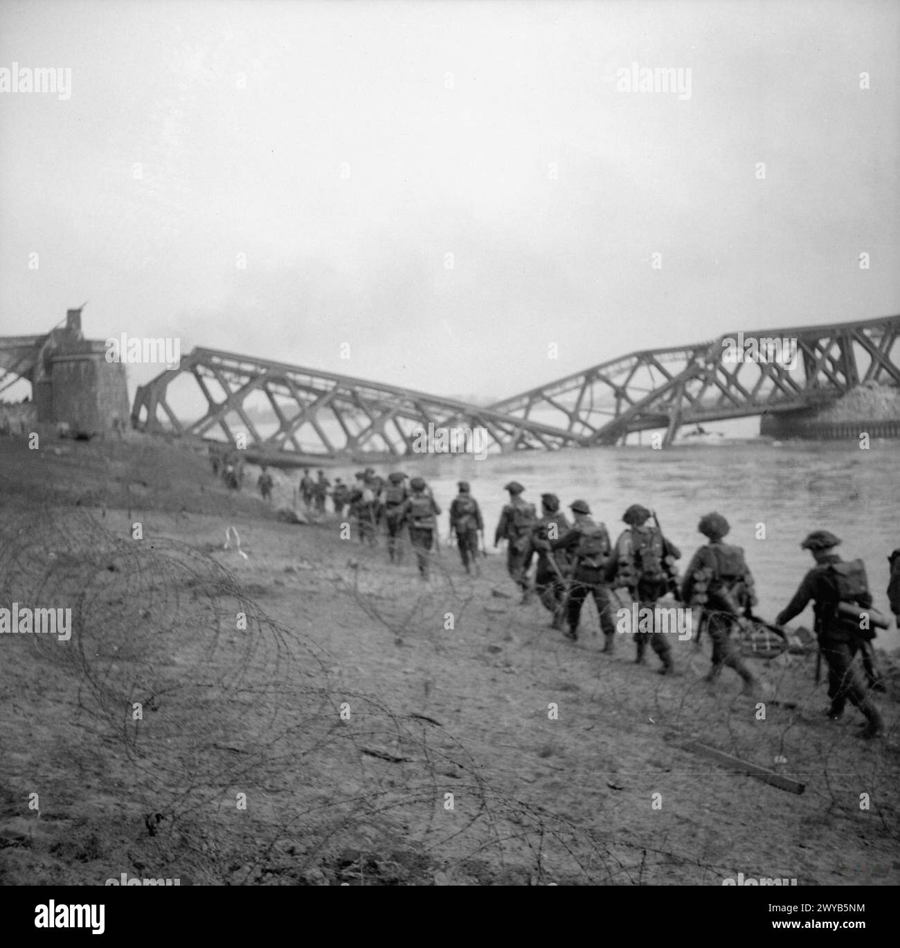 L'ARMÉE BRITANNIQUE EN EUROPE DU NORD-OUEST 1944-45: ASSAUT SUR LE RHIN ET CAPTURE DE WESEL - ceci est l'une d'une collection d'images qui montrent le débarquement des buffles du 1er Bataillon Cheshire Regiment, qui a débarqué dans l'après-midi du 24 mars 1945, en soutien à la Brigade Commando No.1 S.S à Wesel. Le pont vu en arrière-plan est le pont de chemin de fer brisé à Wesel. , Armée britannique, régiment de Cheshire, 1er bataillon Banque D'Images