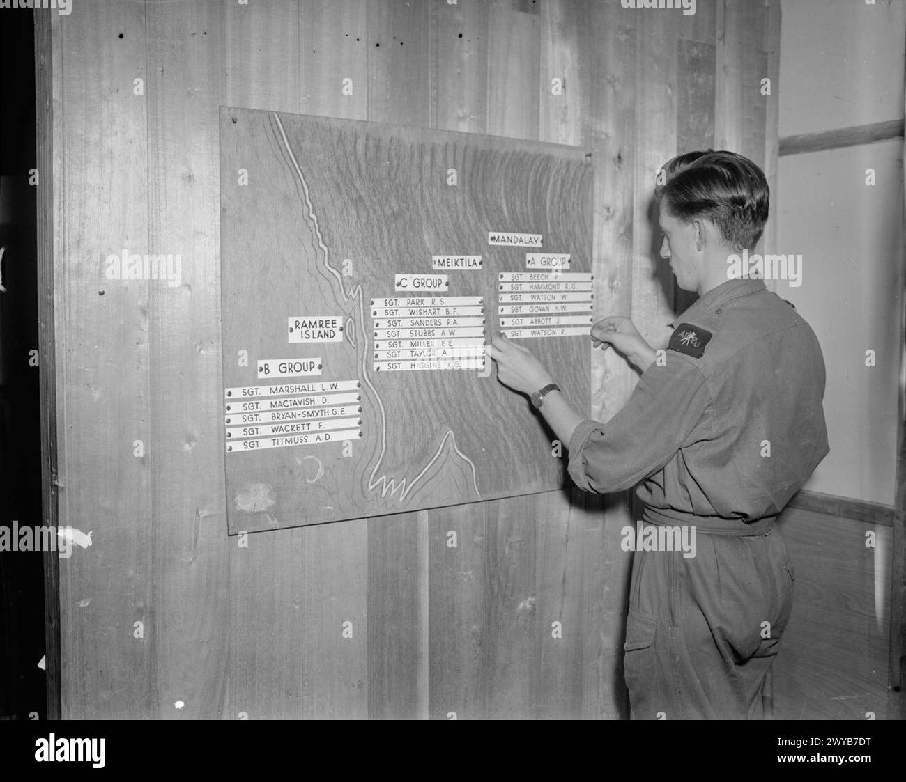 Le sergent R E d Potter attribue des noms sur le tableau « disposition cameraman » de la section du film et de la photo de l'armée no 9, une carte de la Birmanie montrant les groupes A, B et C à Mandalay, Ramree Island et Meiktila, avec le flash AFPU visible sur son épaule gauche. Banque D'Images