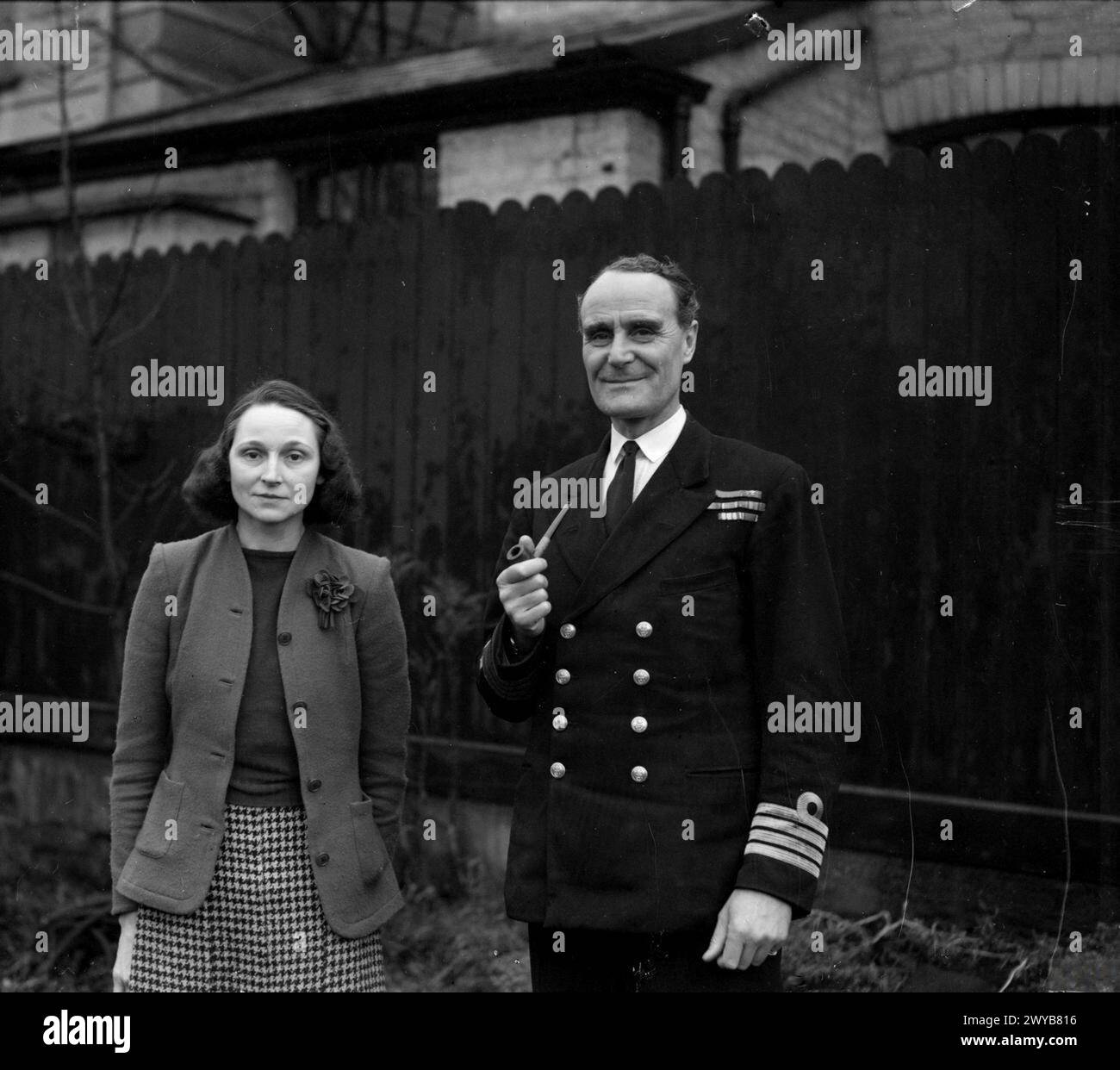 U-BOOT HUNTER NUMÉRO 1. 12 JANVIER 1944, LA MAISON BLANCHE, GARSTON, LIVERPOOL. CAPITAINE F J WALKER, CB, DSO, RN, LE CHASSEUR DE U-BOOT LE PLUS RÉUSSI DE LA GUERRE. IL COMMANDE LE DEUXIÈME GROUPE D'ESCORTE. - Capitaine F J Walker avec sa femme dans les jardins de leur maison près de Liverpool. , Banque D'Images