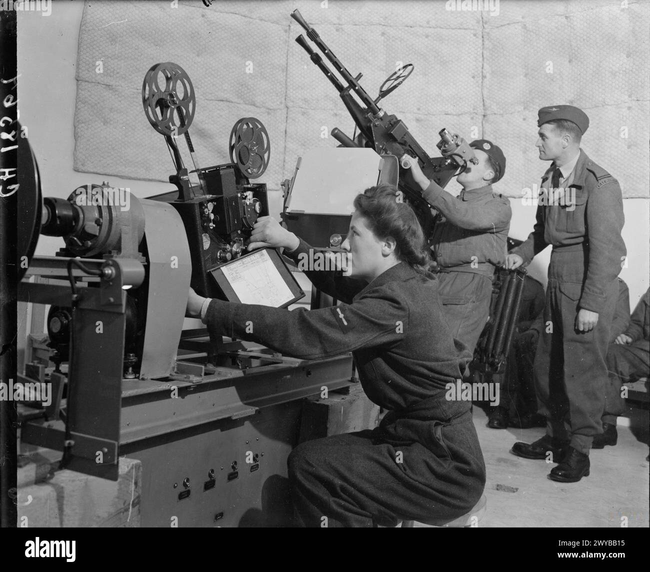 Un membre du Royal Air Force Regiment reçoit une formation dans un dôme d'instructeur anti-aérien à la RAF Leuchars tandis qu'un membre de la Women's Auxiliary Air Force projette des films ciblés. Banque D'Images