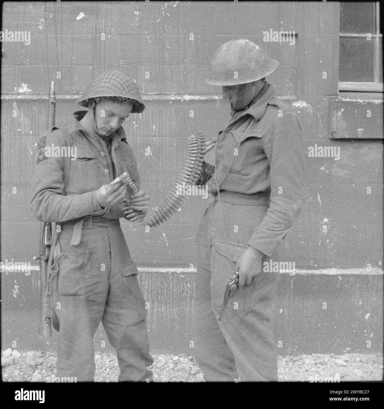 Des soldats de la 3e division à Caen examinent une ceinture de mitrailleuses Hotchkiss le 10 juillet 1944. Banque D'Images