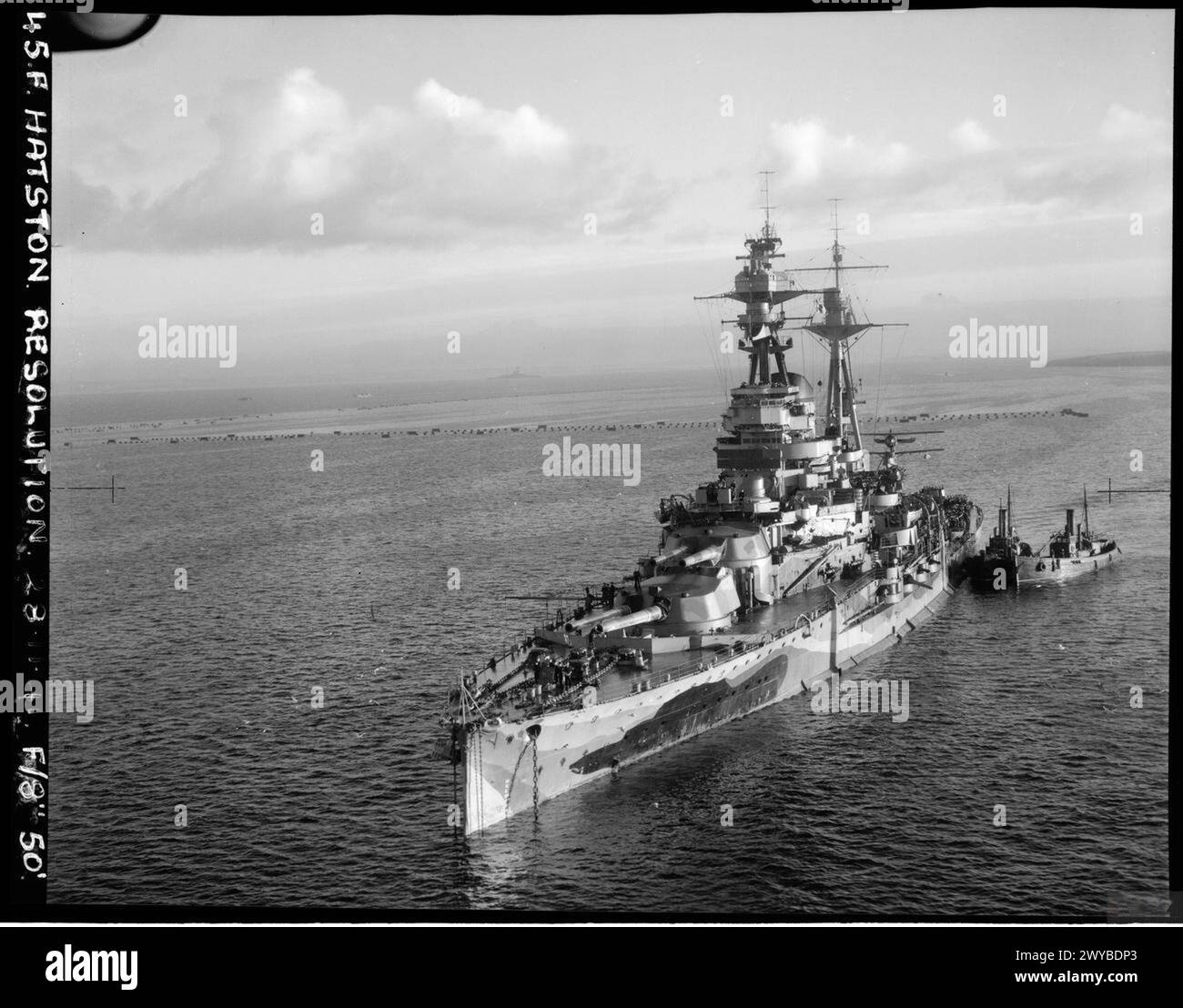 Le HMS Resolution est au mouillage, stationné dans un port. Le cuirassé appartient à la Royal Navy et est sécurisé pour le repos ou le ravitaillement. Banque D'Images