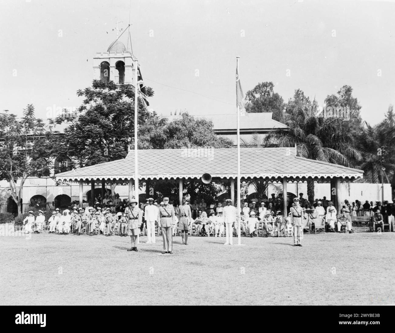 JOURNÉE DE L'URSS À BATHURST, GAMBIE. 23 FÉVRIER 1943. - Le drapeau de l'Union Soviétique et l'Union Jack volant côte à côte alors que son Excellence l'honorable H R R Blood, gouverneur de Gambie, s'avançait pour prendre le salut lors des célébrations de Bathurst de l'URSS. À la droite de son Excellence se trouve le brigadier Burden (commandant de secteur) ; au quatrième à partir de la gauche, l'honorable Shiek Omar Fye Senior (membre non officiel du Conseil législatif) et, contre le mât (à droite), l'honorable M. le juge Johnson. , Banque D'Images