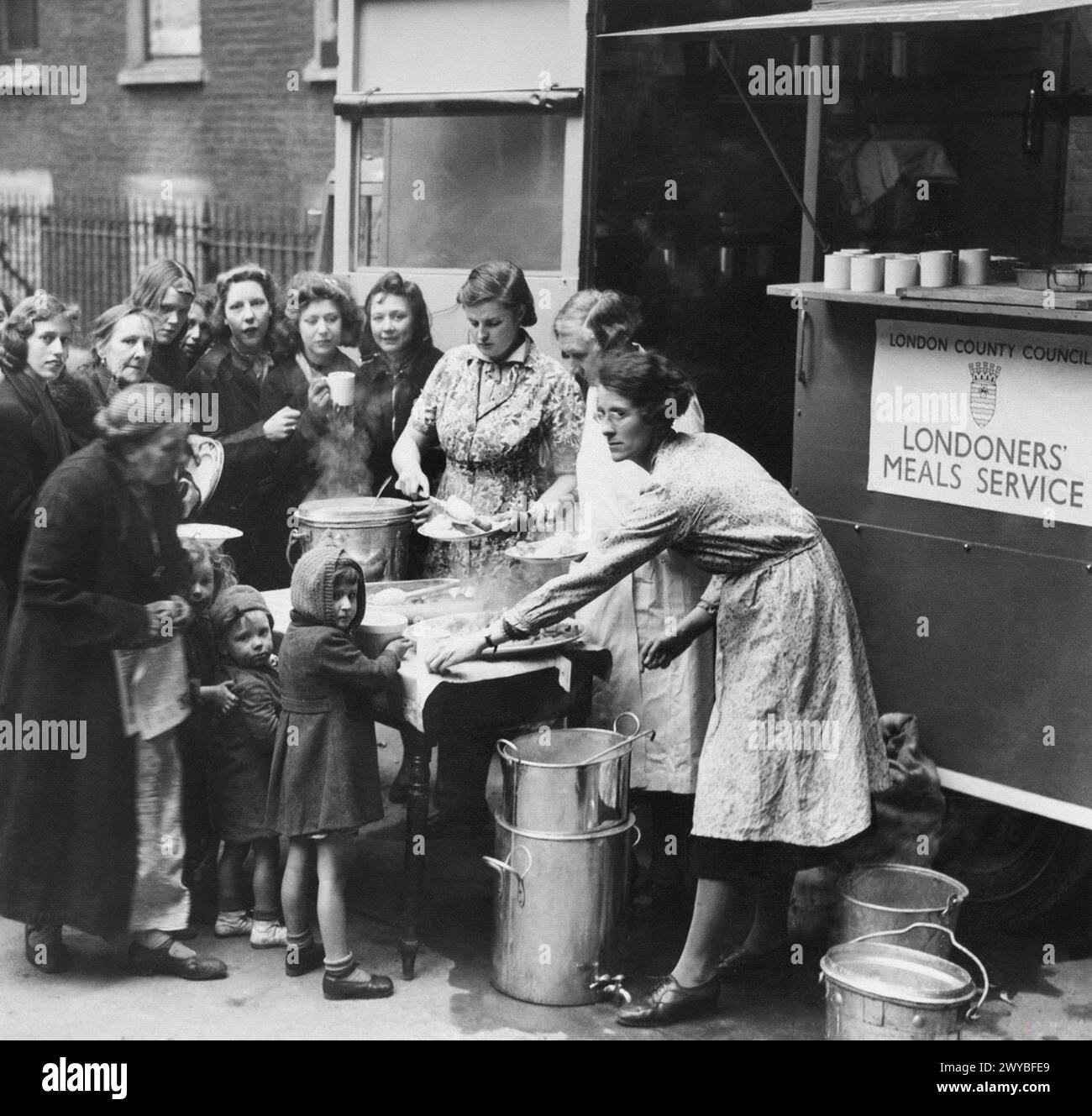 Pendant le Blitz de Londres 1940-1941, les enseignants servent de la nourriture à partir d'une cantine mobile « Londoners Meal Service » aux femmes et aux enfants. Banque D'Images