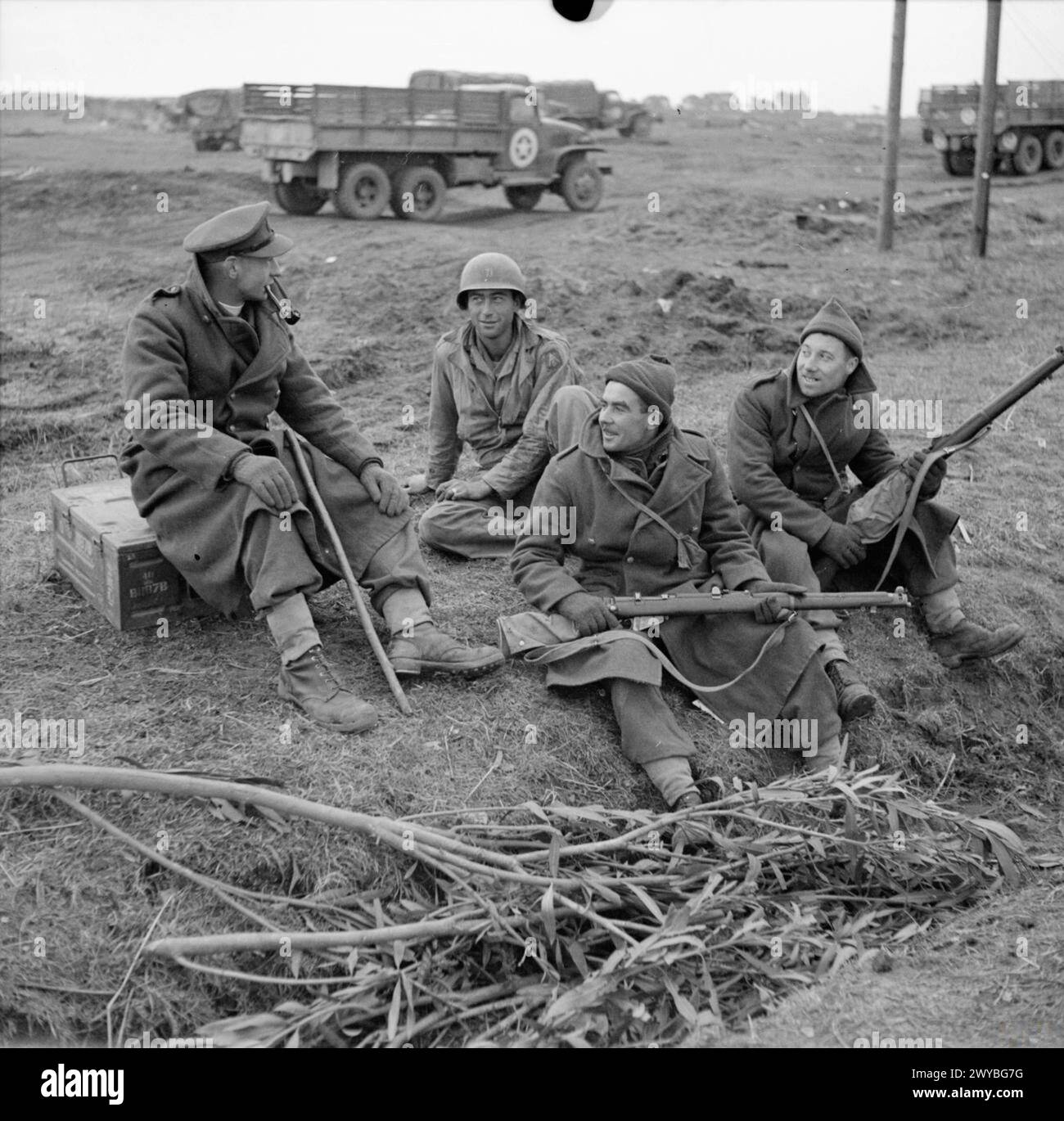 Le révérend G. B. Fairhurst, Padre du 2/5th Queen's Regiment, s'entretient avec deux soldats et un soldat américain à la tête de pont d'Anzio, en Italie, les 20 et 21 février 1944. Banque D'Images