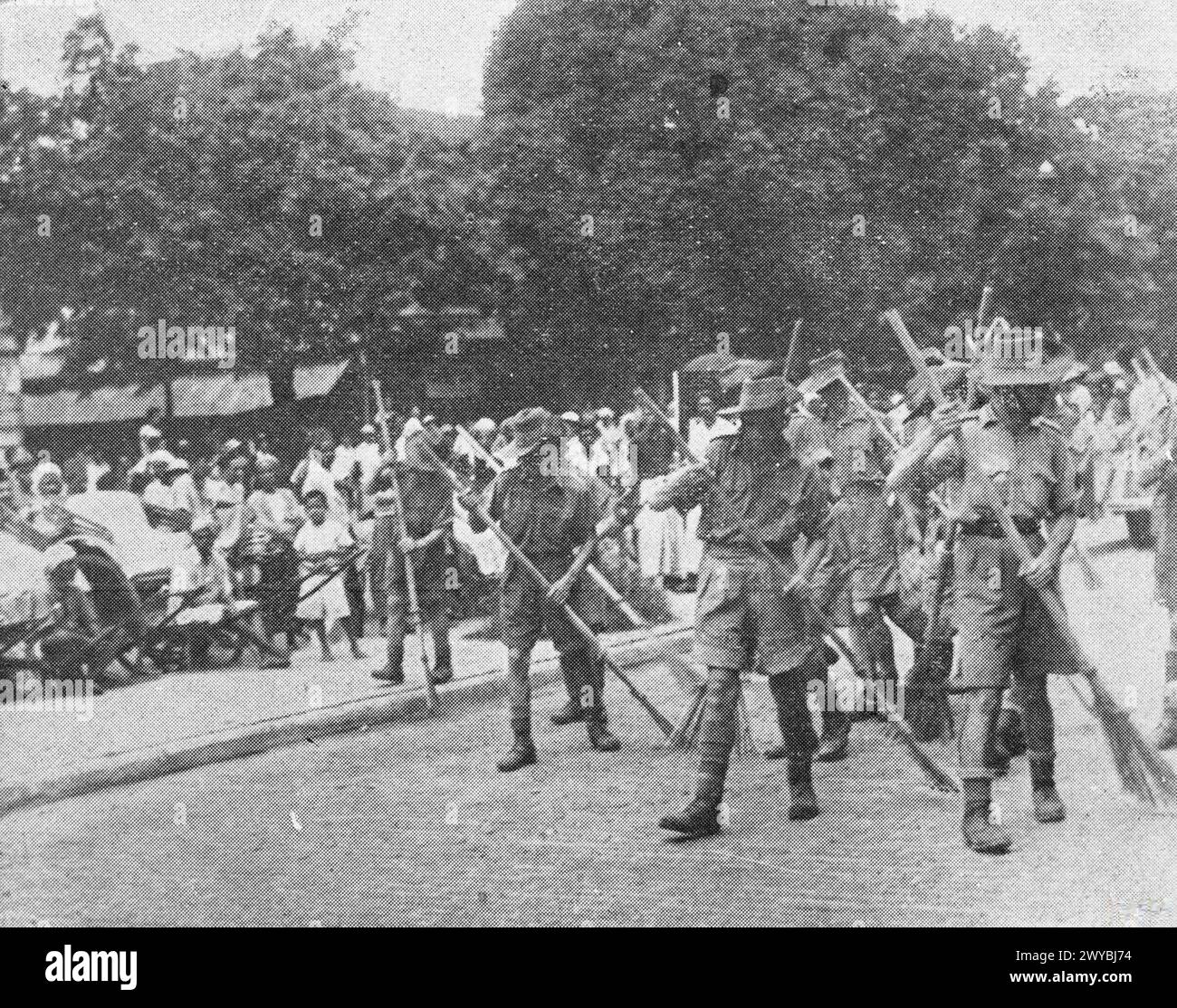 Prisonniers de guerre alliés sous contrôle japonais balayant les rues en Malaisie et à Singapour après la chute des deux territoires, 1942. Banque D'Images