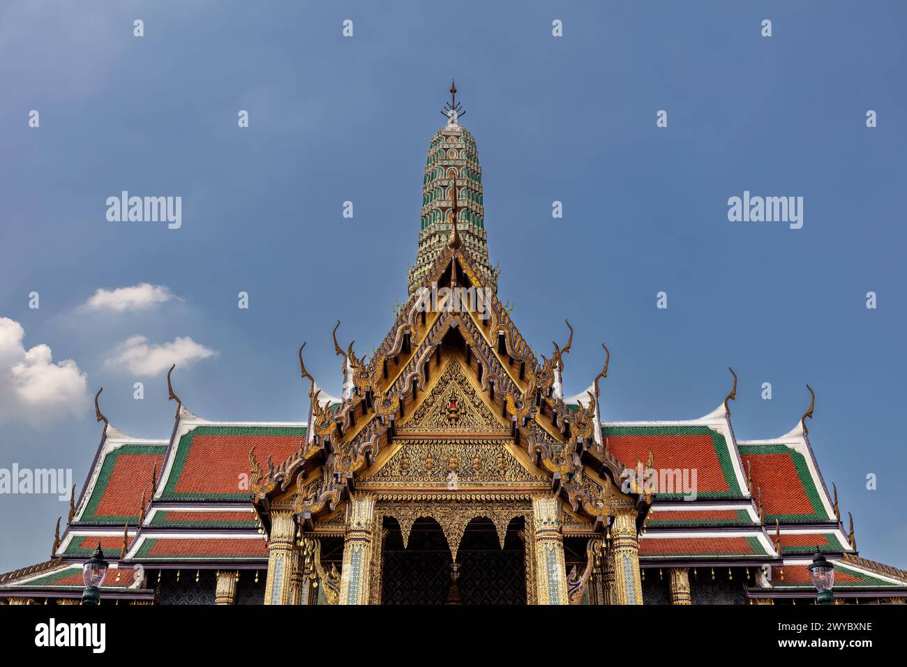 Temple au Grand Palais (Wat Phra Kawe) à Bangkok, Thaïlande. Décorations dorées ornées ; toit en tuiles vertes, rouges et oranges. Prang décoré en arrière-plan. B Banque D'Images