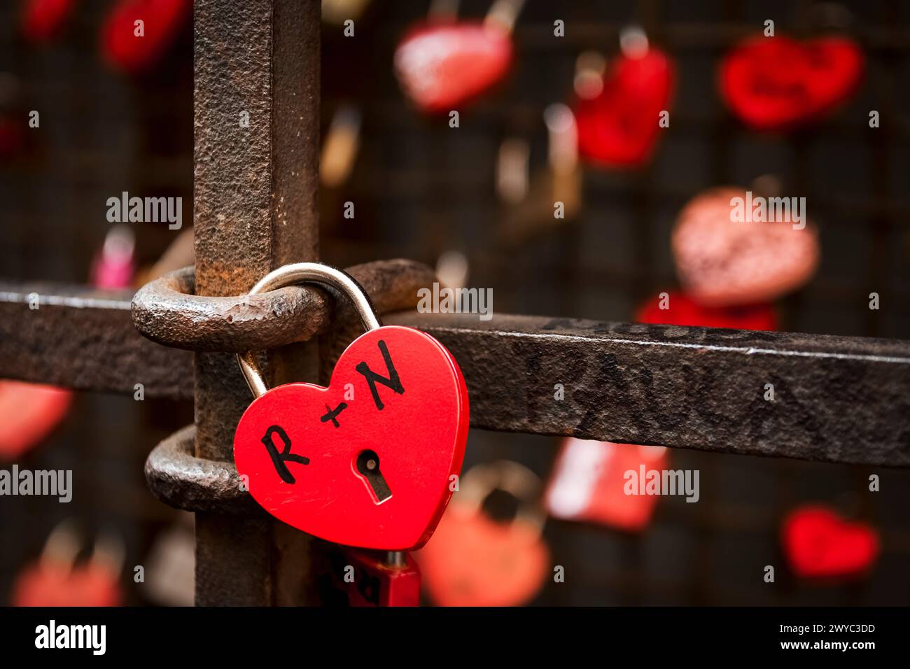 cadenas en forme de coeur rouge attachés aux balustrades pour exprimer l'amour entre deux petits amis Banque D'Images