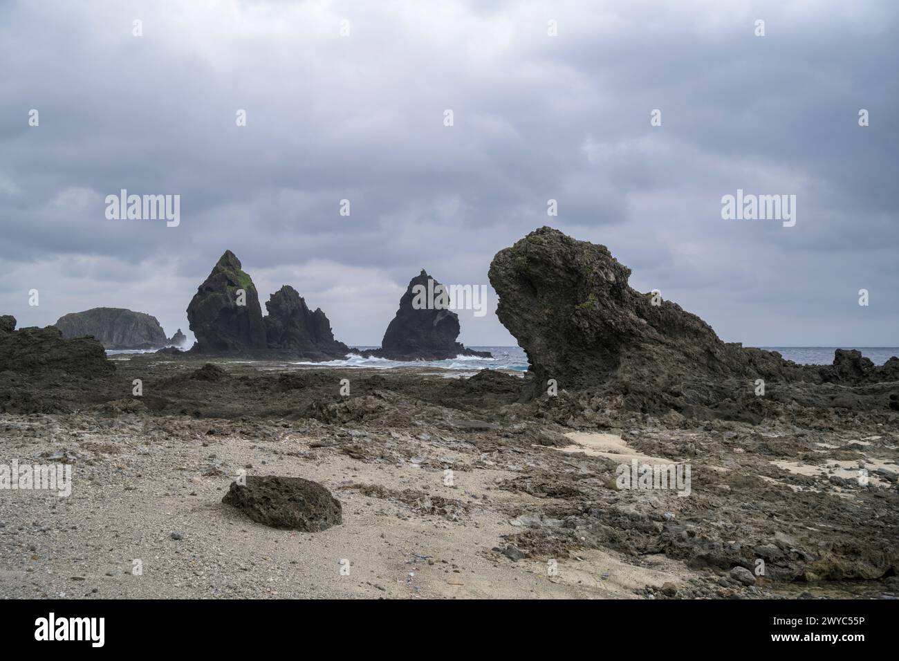 Moody Skies couvre un paysage marin féroce avec de grandes formations rocheuses et des vagues turbulentes qui s'écrasent contre eux Banque D'Images