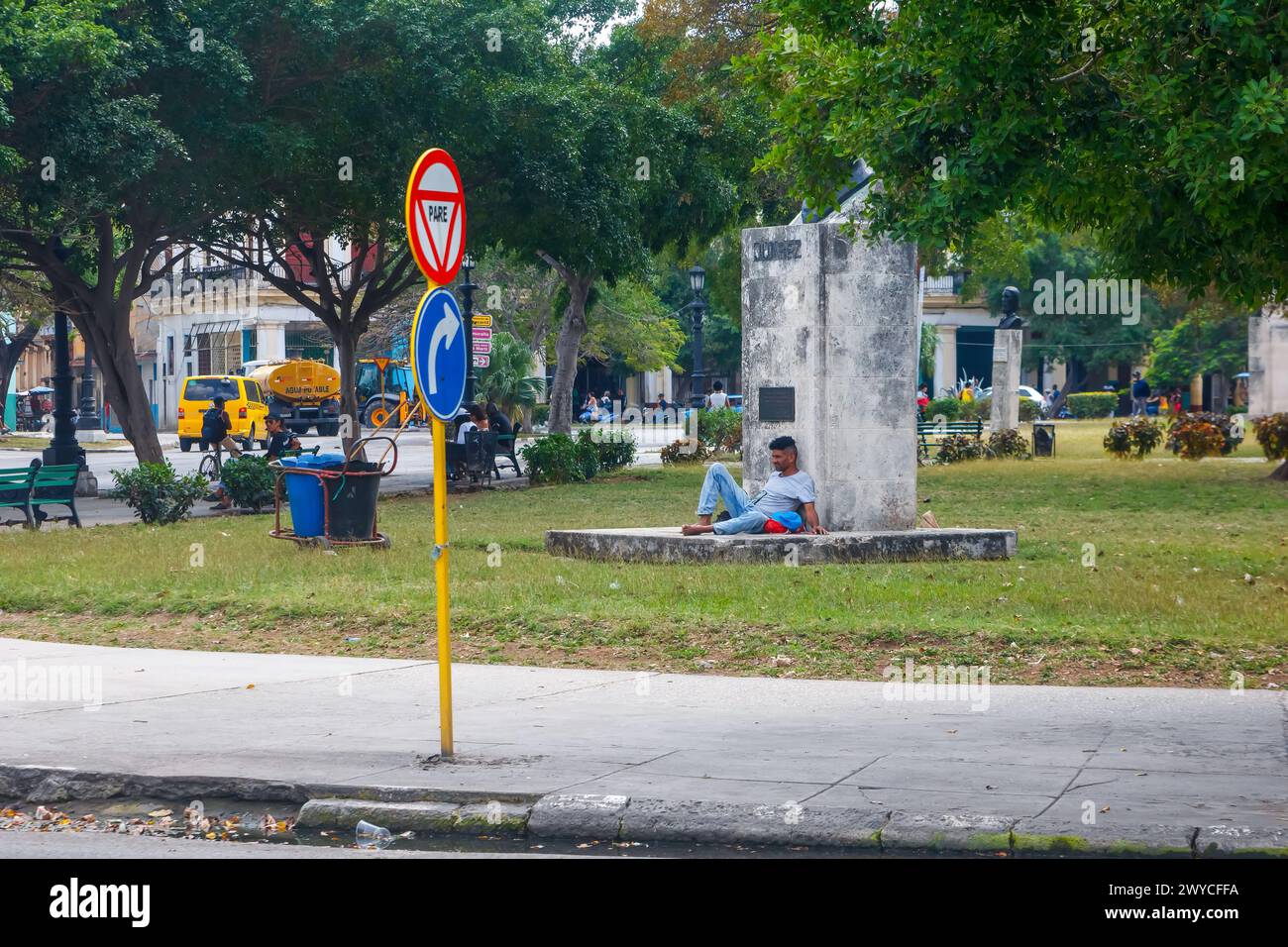 Homme cubain assis au pied d'un monument sur une place à la Havane, Cuba Banque D'Images