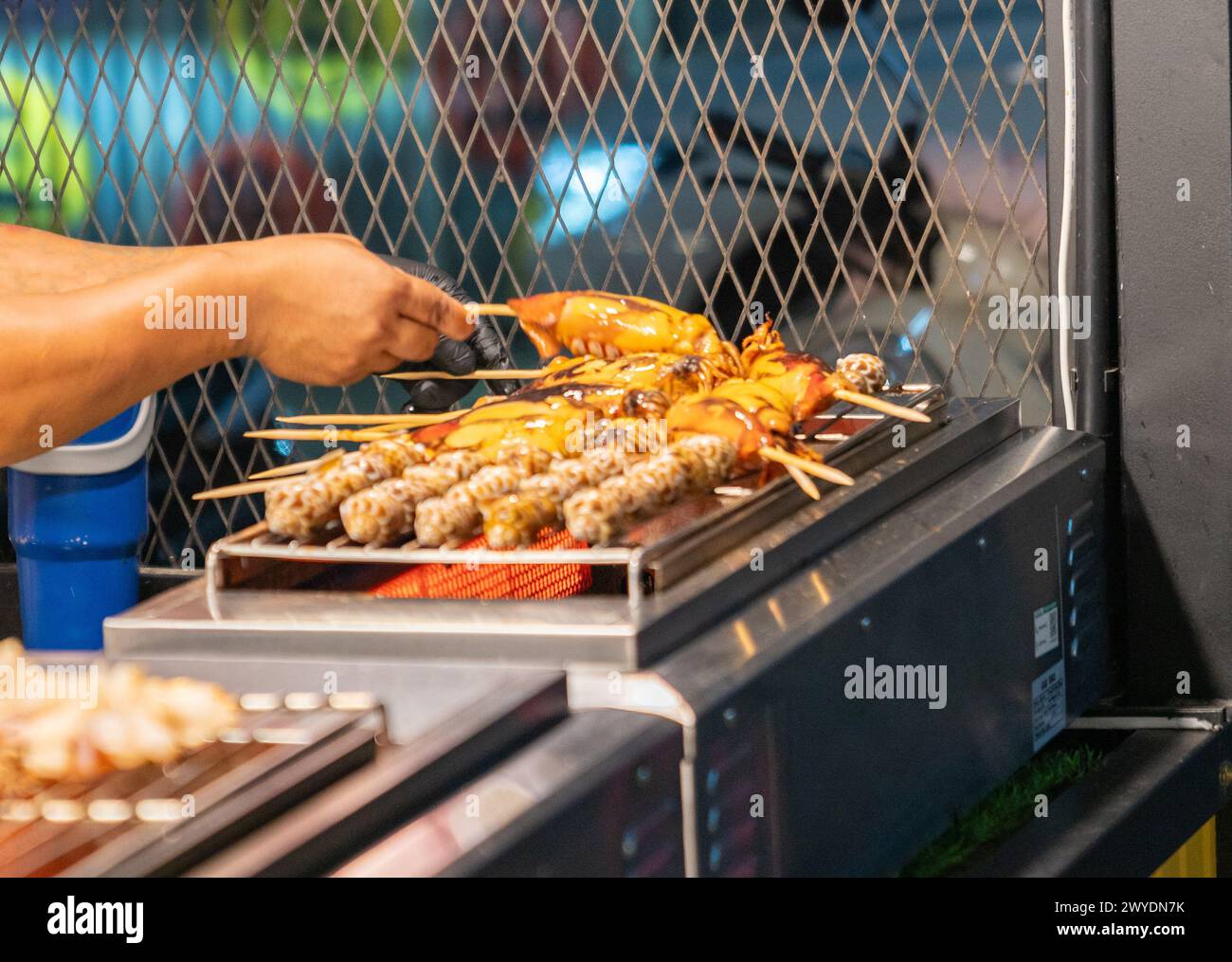 Calmars grillés avec bâton dans un marché de nourriture de rue. Banque D'Images