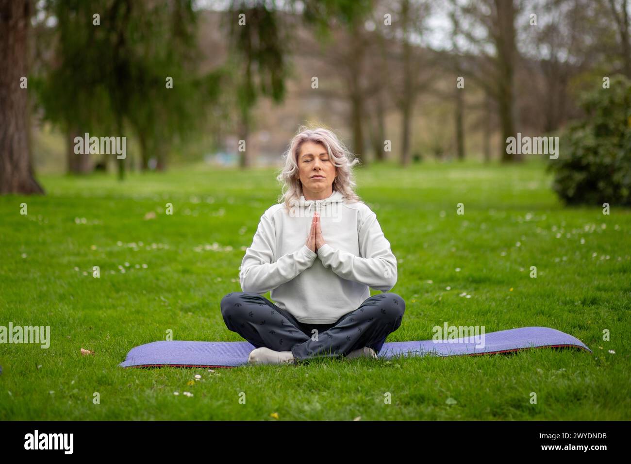 Femme assise dans le lotus pose dehors, méditant. Banque D'Images