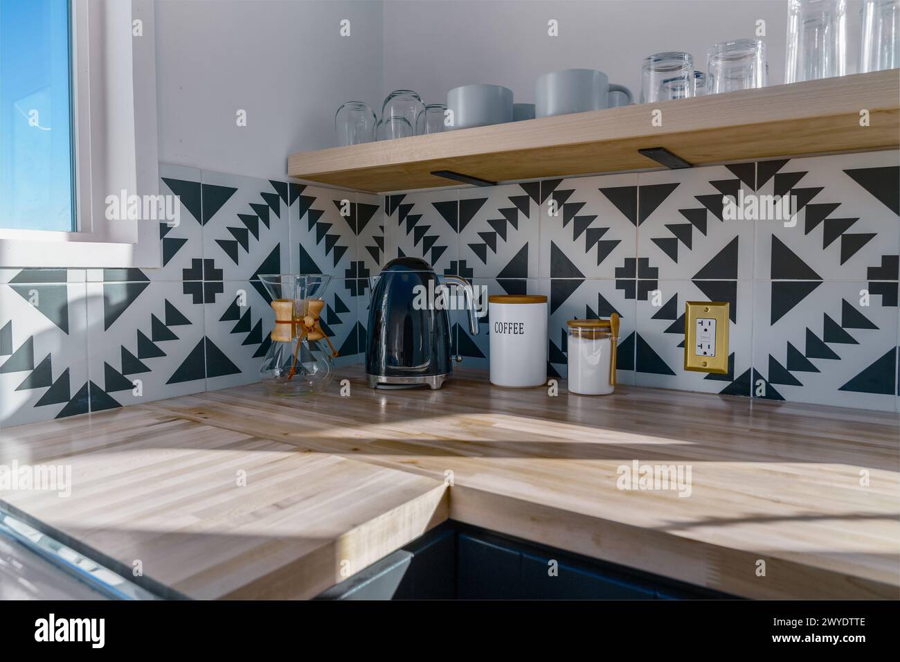 Coin café dans une cafetière en verre récipients d'infusion et tasses verres dans une cuisine moderne avec carrelage noir et blanc Banque D'Images