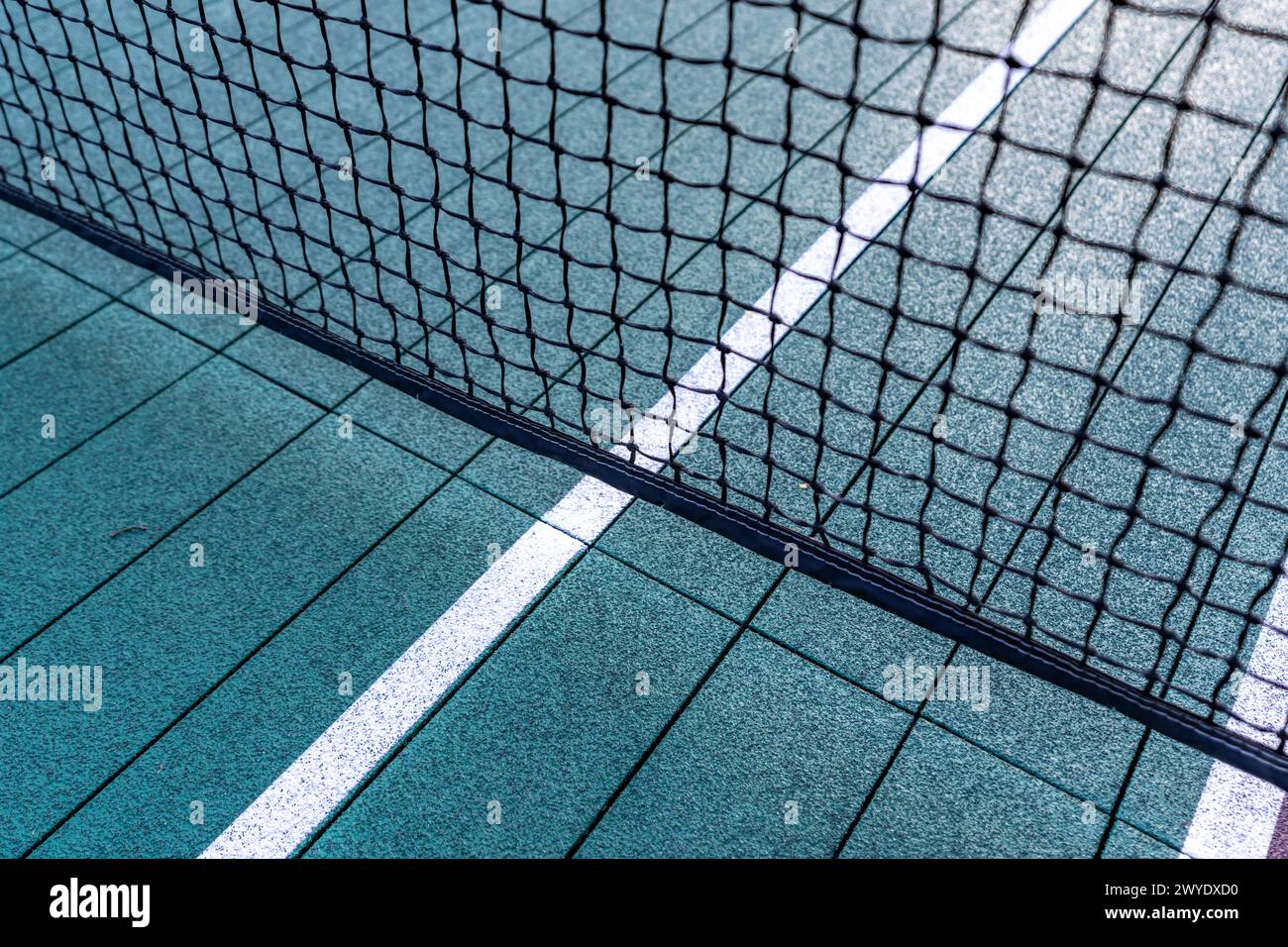 Tennis à plate-forme surélevée, courts de paddle-ball avec lignes de pickelball jaunes et filet. La surface du sol est verte avec du blanc et du jaune Banque D'Images