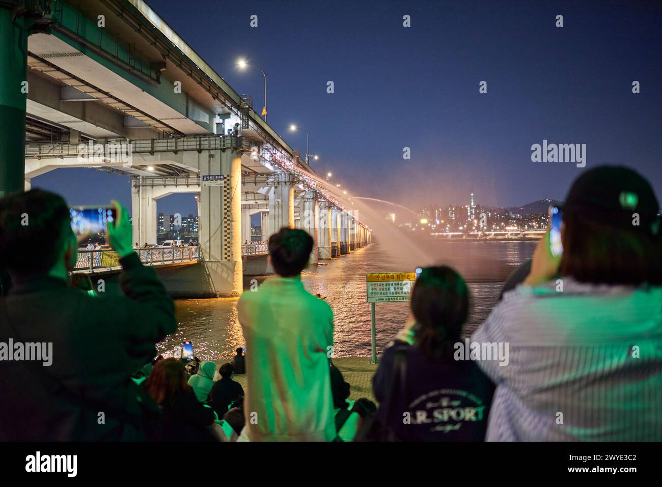 Les gens regardent la fontaine arc-en-ciel colorée de Banpo Bridge Moonlight à Séoul, Corée du Sud, le 5 avril 2024 Banque D'Images