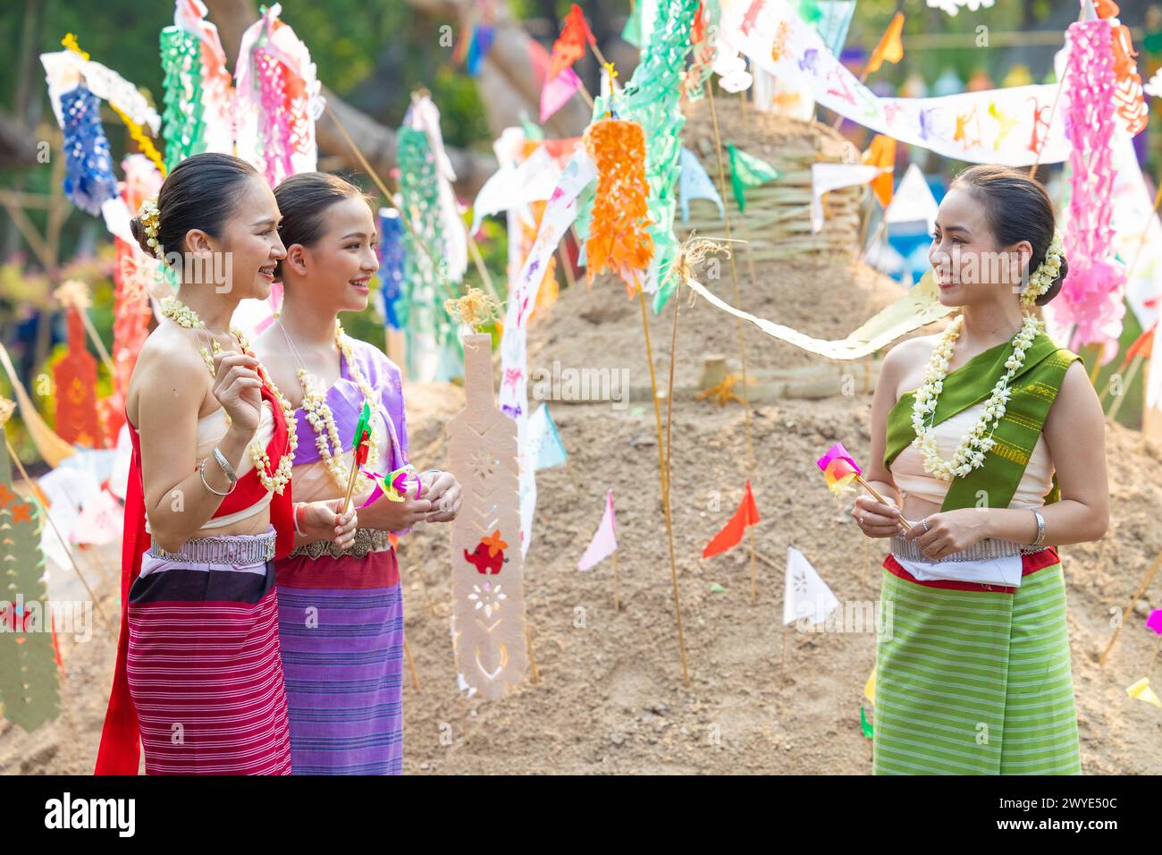 Festival Songkran. Peuple thaïlandais du Nord dans des vêtements traditionnels habillant portant du sable dans le temple pour construire la pagode de sable et la décoration avec PA coloré Banque D'Images