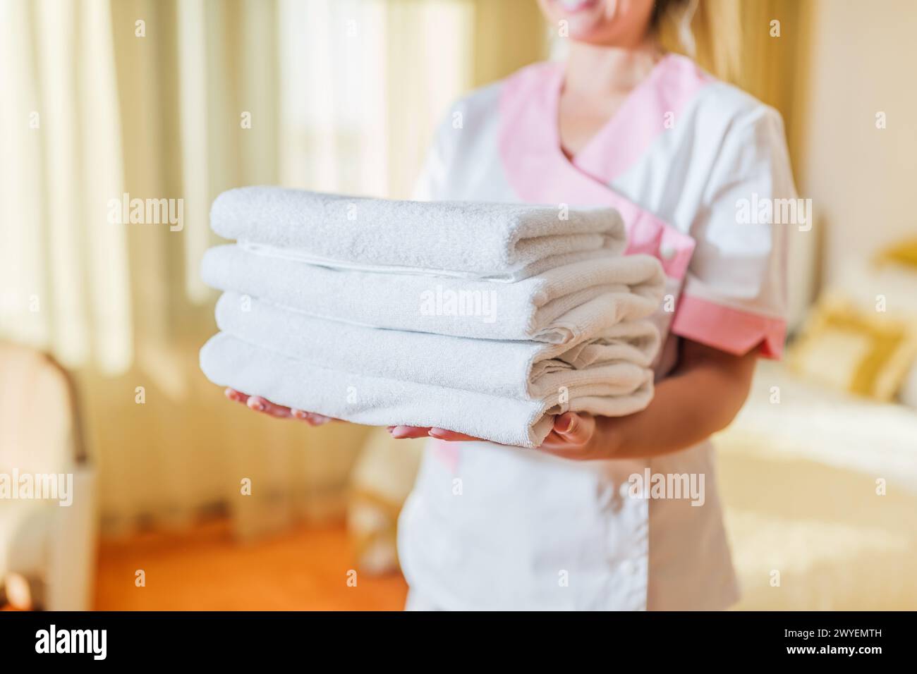 Image rapprochée d'une femme de chambre d'hôtel tenant des serviettes propres et propres. Banque D'Images