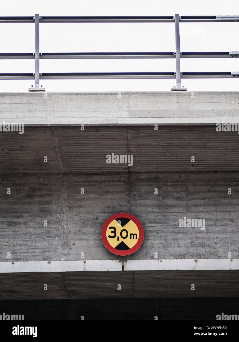 Un panneau rouge et jaune est bien en vue au-dessus d'un tunnel, fournissant des informations ou des avertissements importants aux véhicules et aux piétons qui passent. Le si Banque D'Images
