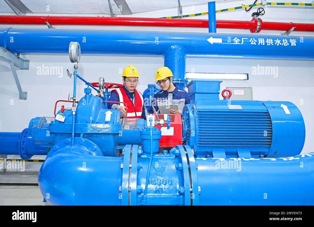 WUHU, CHINE - 6 AVRIL 2024 - des ouvriers révisent et entretiennent un groupe électrogène dans un bâtiment souterrain du groupe Xiangshuijian du réseau d'État Xinyuan Banque D'Images