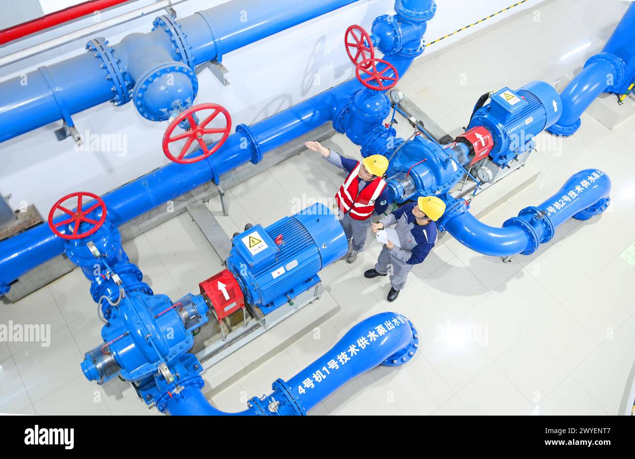 WUHU, CHINE - 6 AVRIL 2024 - des ouvriers révisent et entretiennent un groupe électrogène dans un bâtiment souterrain du groupe Xiangshuijian du réseau d'État Xinyuan Banque D'Images