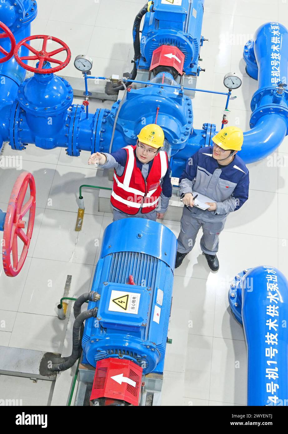 WUHU, CHINE - 6 AVRIL 2024 - des ouvriers révisent et entretiennent un groupe électrogène dans un bâtiment souterrain du groupe Xiangshuijian du réseau d'État Xinyuan Banque D'Images