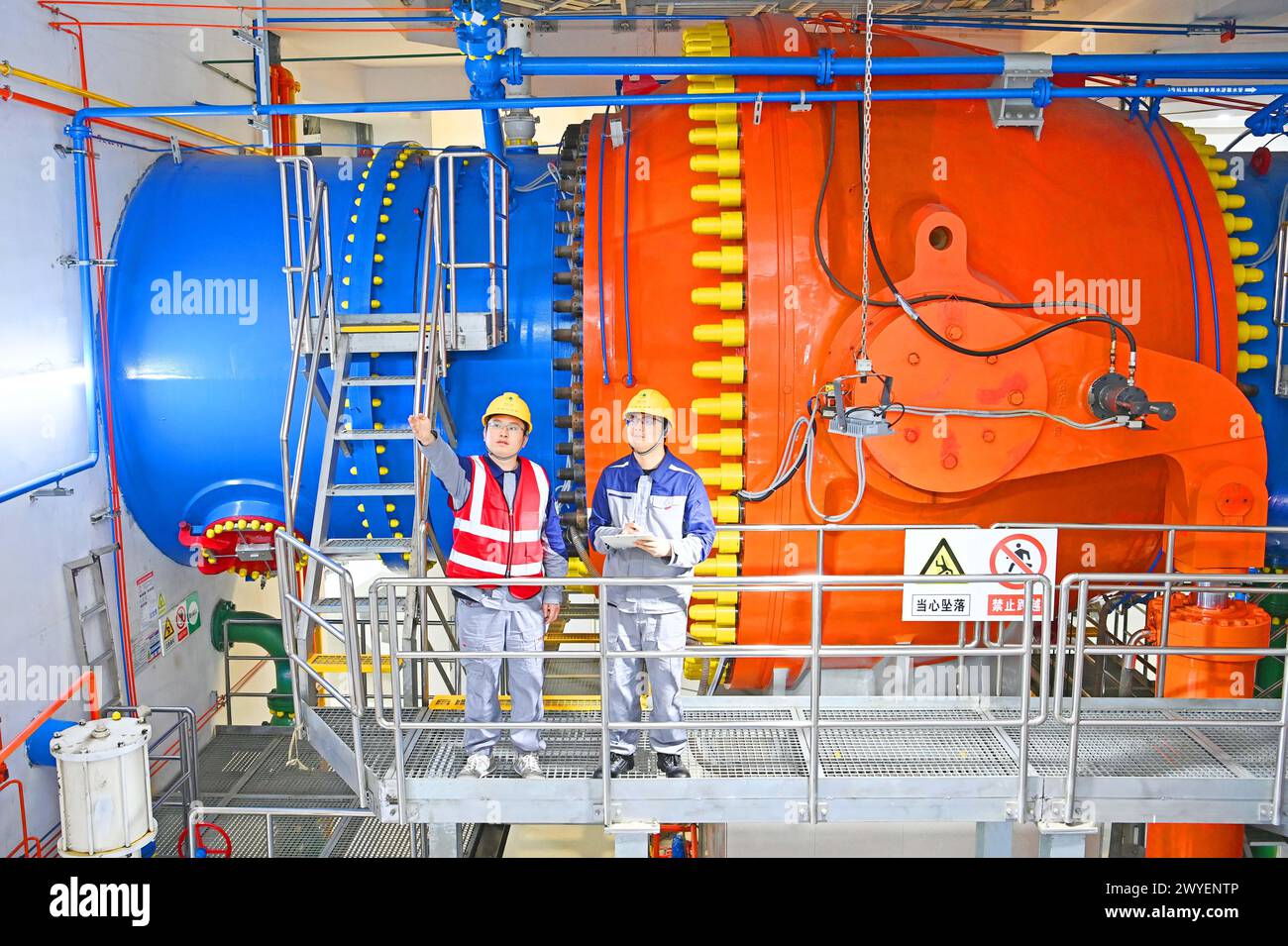 WUHU, CHINE - 6 AVRIL 2024 - des ouvriers révisent et entretiennent un groupe électrogène dans un bâtiment souterrain du groupe Xiangshuijian du réseau d'État Xinyuan Banque D'Images