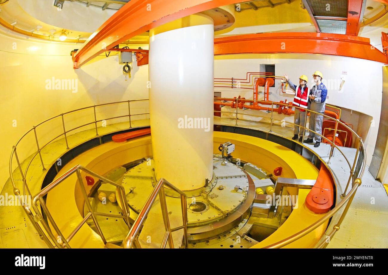 WUHU, CHINE - 6 AVRIL 2024 - des ouvriers révisent et entretiennent un groupe électrogène dans un bâtiment souterrain du groupe Xiangshuijian du réseau d'État Xinyuan Banque D'Images