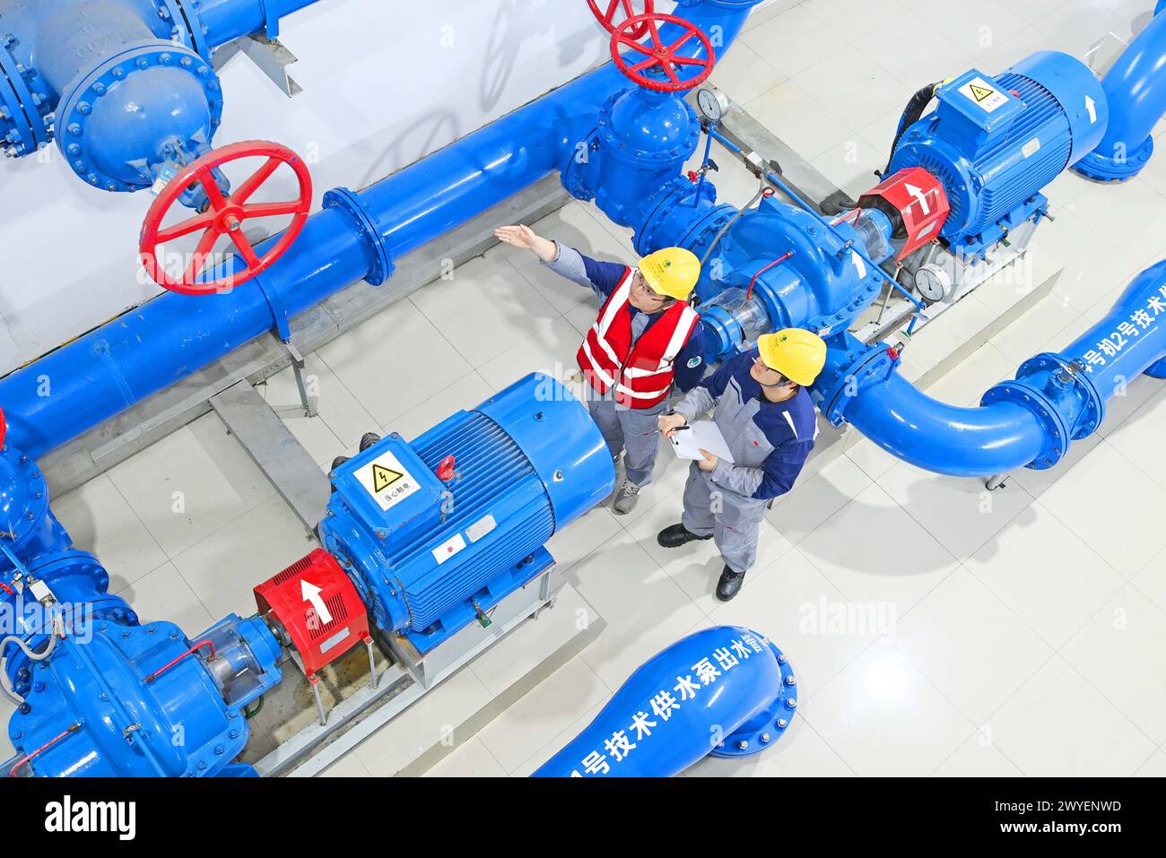 WUHU, CHINE - 6 AVRIL 2024 - des ouvriers révisent et entretiennent un groupe électrogène dans un bâtiment souterrain du groupe Xiangshuijian du réseau d'État Xinyuan Banque D'Images