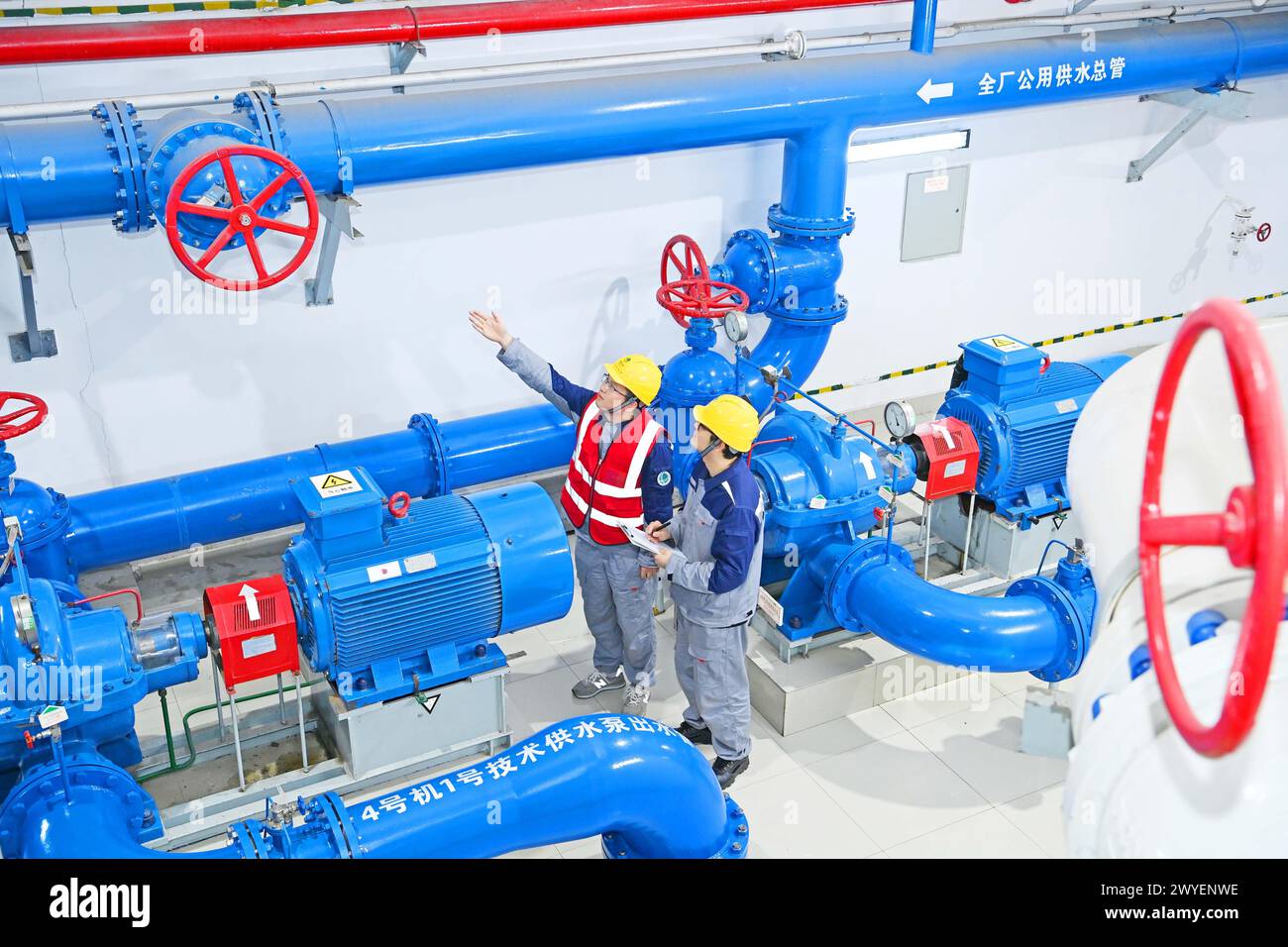 WUHU, CHINE - 6 AVRIL 2024 - des ouvriers révisent et entretiennent un groupe électrogène dans un bâtiment souterrain du groupe Xiangshuijian du réseau d'État Xinyuan Banque D'Images