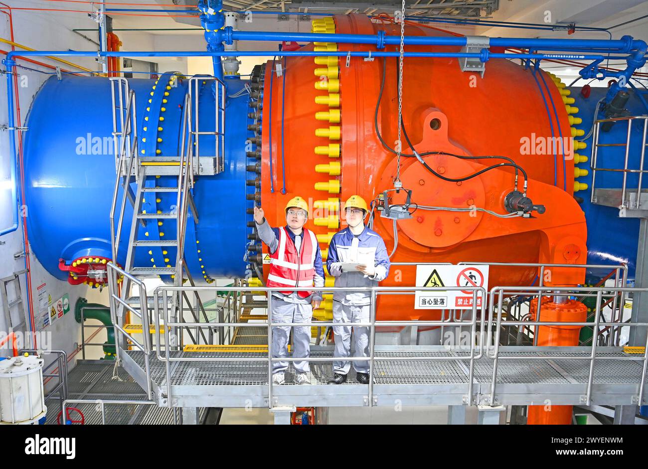 WUHU, CHINE - 6 AVRIL 2024 - des ouvriers révisent et entretiennent un groupe électrogène dans un bâtiment souterrain du groupe Xiangshuijian du réseau d'État Xinyuan Banque D'Images
