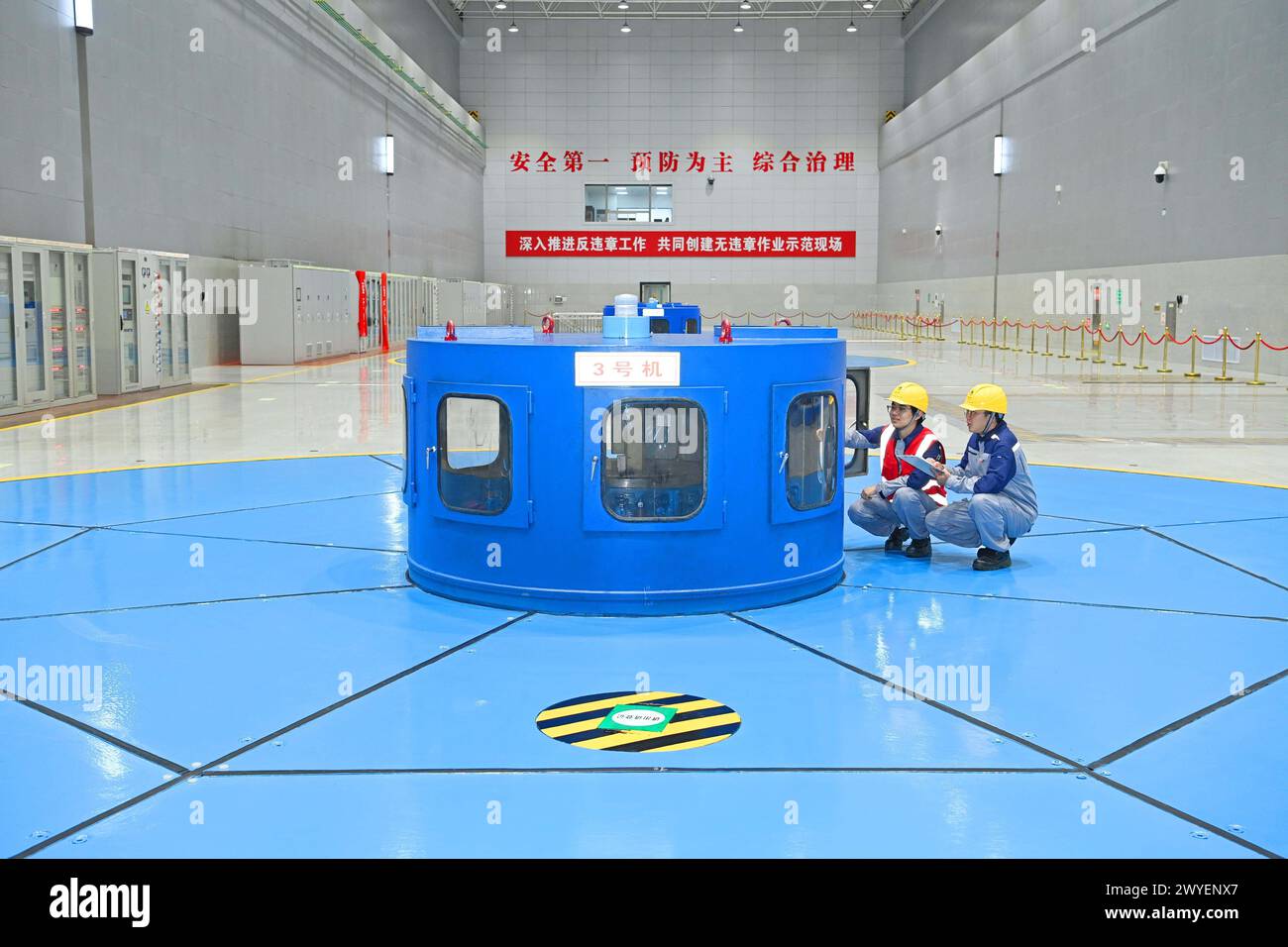 WUHU, CHINE - 6 AVRIL 2024 - des ouvriers révisent et entretiennent un groupe électrogène dans un bâtiment souterrain du groupe Xiangshuijian du réseau d'État Xinyuan Banque D'Images