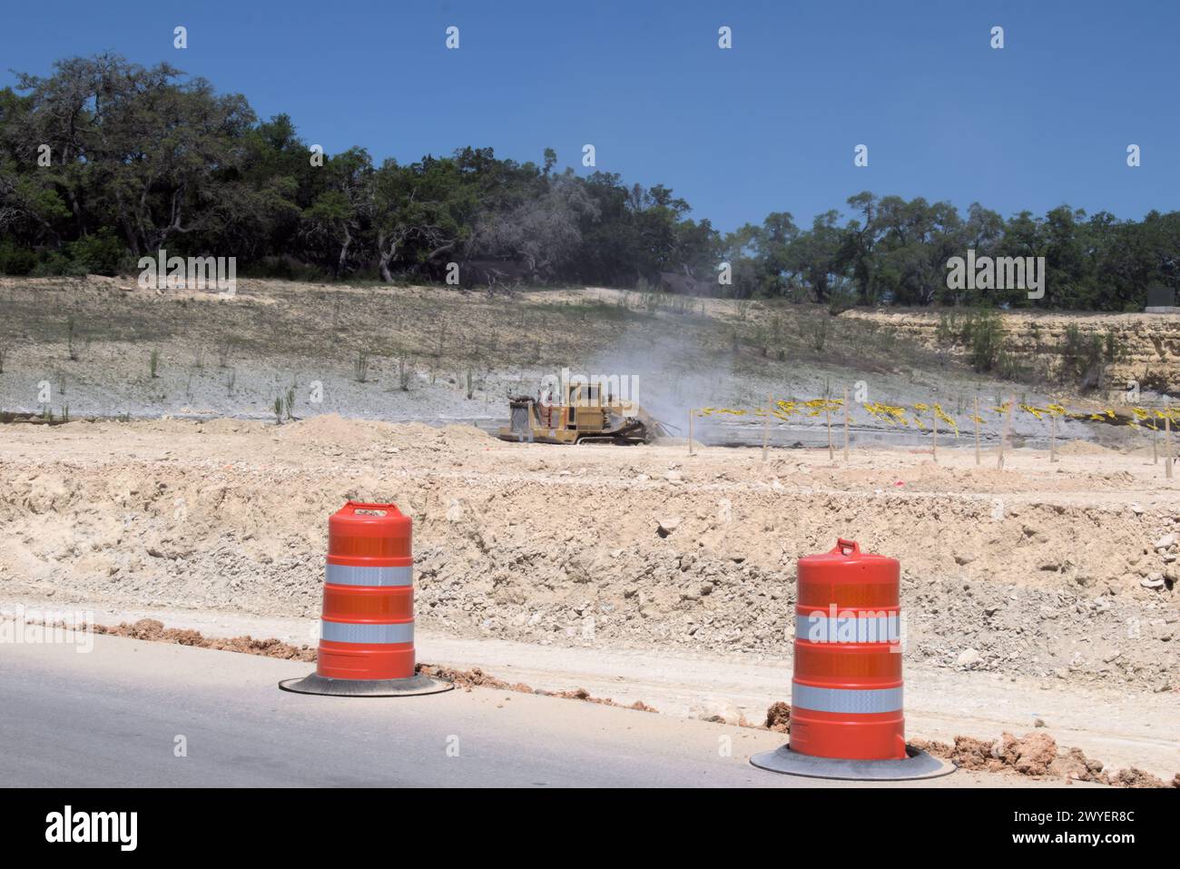 Équipement d'excavation nivelant les collines du Texas Hill Country pour soutenir l'étalement urbain, que beaucoup voient comme une transformation négative à la vie rurale/ranch. Banque D'Images