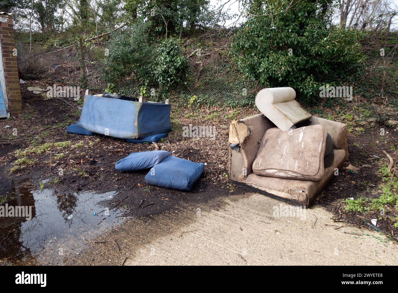 Un fauteuil canapé abandonné et déversé dans les garages Flytipped in the Rain Banque D'Images