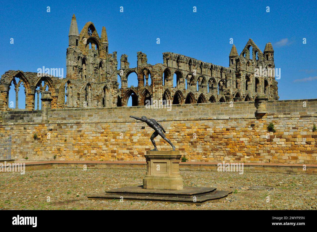 Le gladiateur Borghese contre le grès doré de la cour pavée en face de la maison de l'abbaye de Whitby avec les ruines de l'abbaye de Whitby en th Banque D'Images