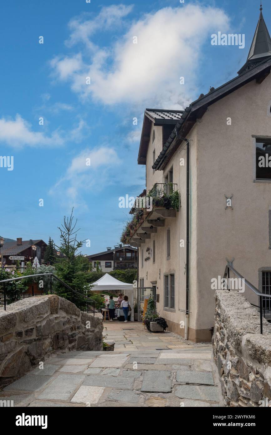 Ancien pont en pierre sur le ruisseau Glapet avec la Maison des Frères, siège de l'Office de Tourisme de la station de ski alpin populaire, Megève, France Banque D'Images