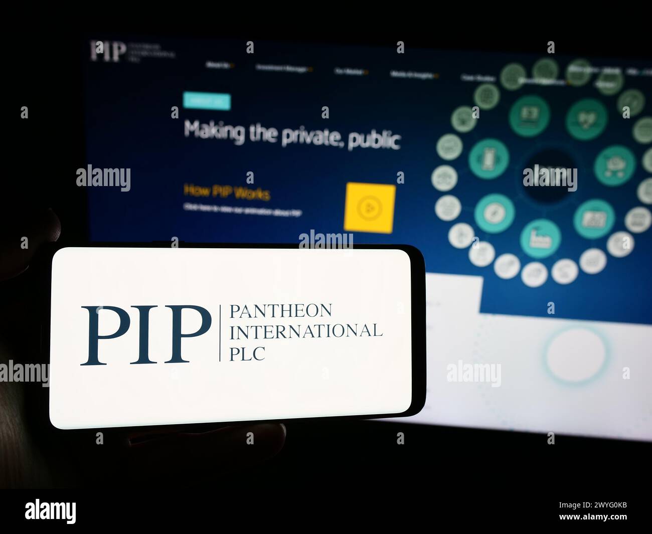 Personne tenant un smartphone avec le logo de la société britannique Pantheon International plc (PIP) en face du site Web. Concentrez-vous sur l'affichage du téléphone. Banque D'Images