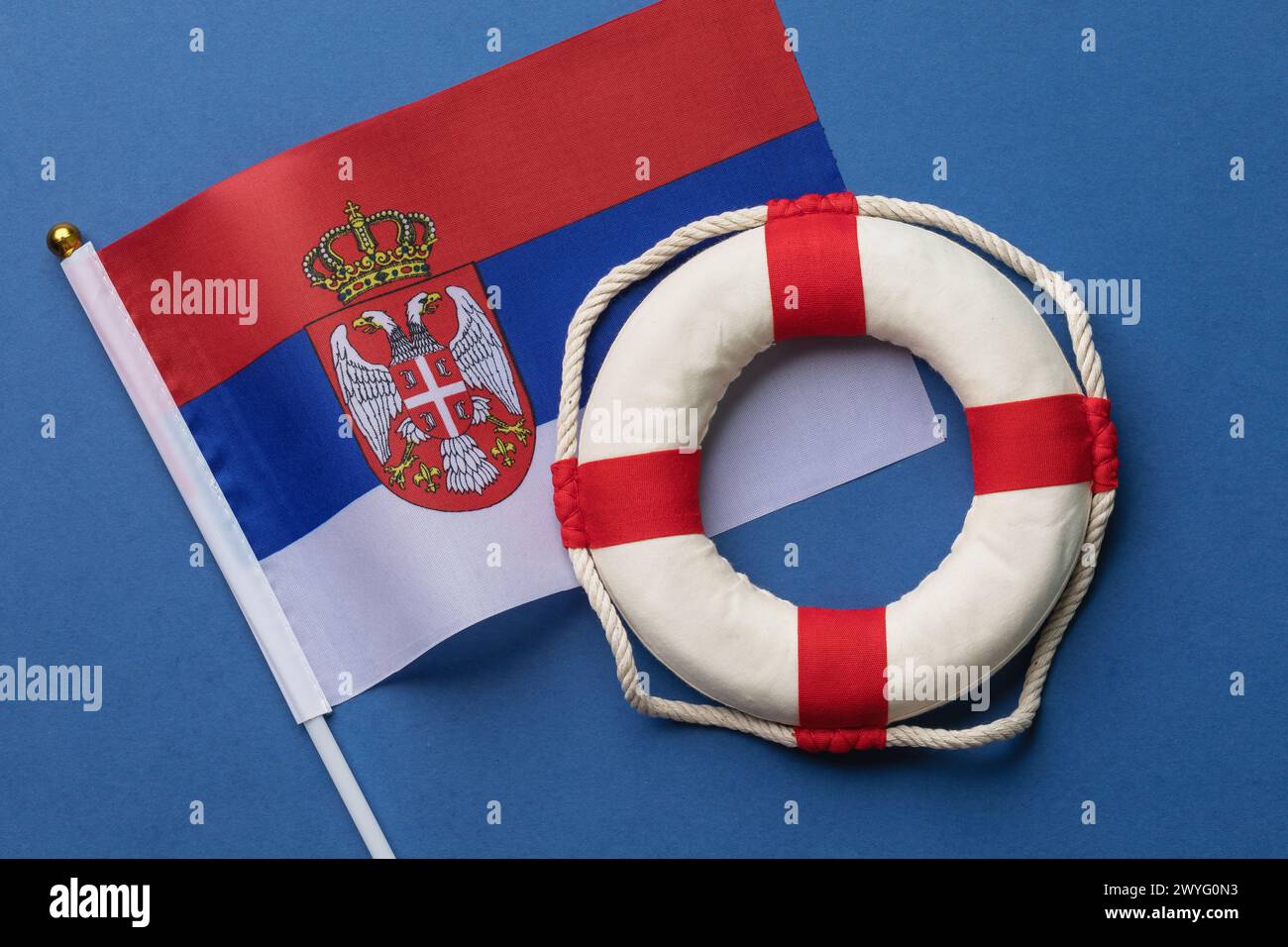 Drapeau serbe et bouée de sauvetage sur un fond coloré, concept sur le thème de l'aide Banque D'Images