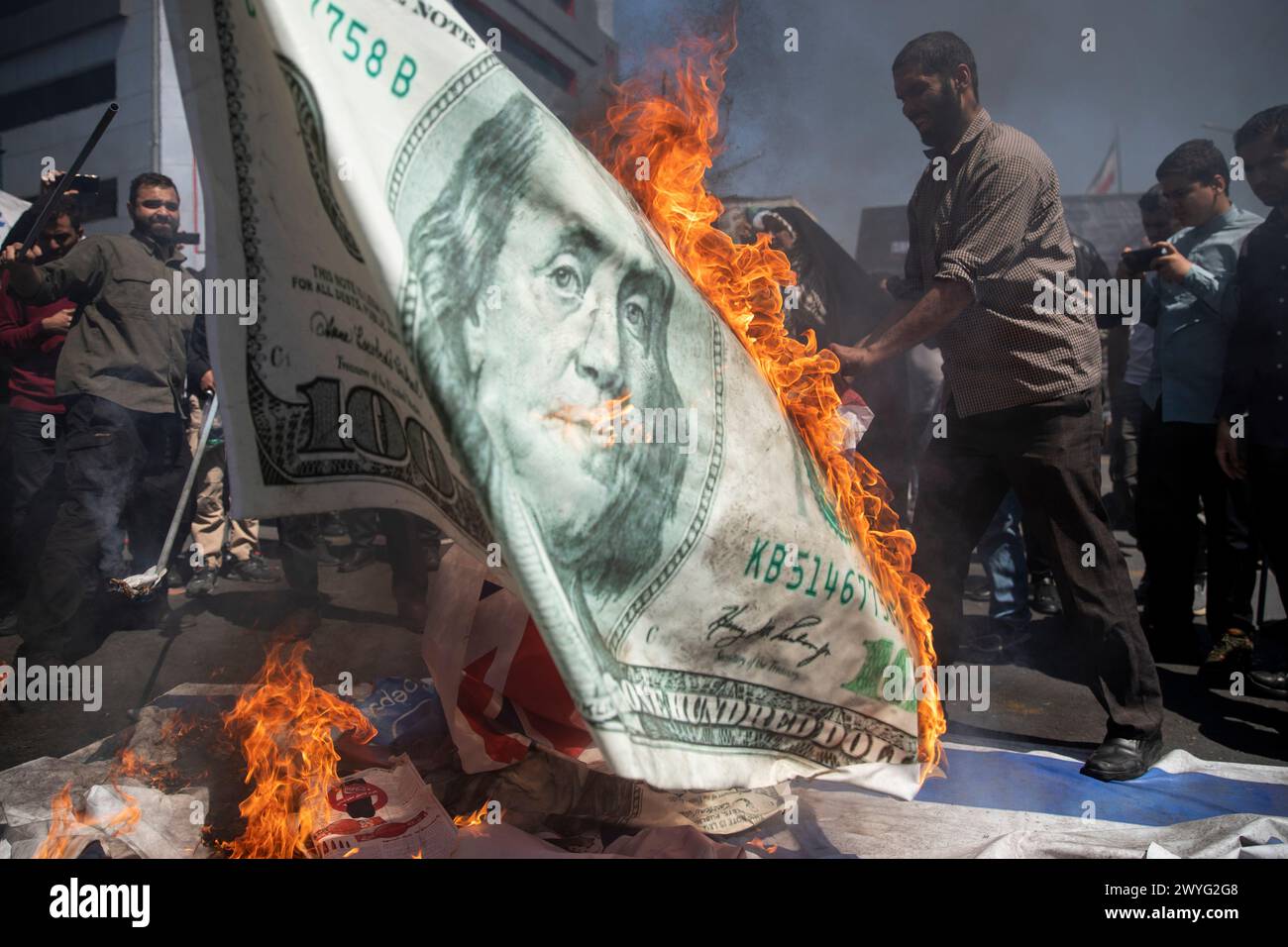 Téhéran, Iran. 5 avril 2024. Des manifestants iraniens brûlent une copie du dollar lors d'un rassemblement annuel pour marquer la Journée de Qods, ou Journée de Jérusalem, en soutien aux Palestiniens. Lors du rassemblement à Téhéran, des milliers de personnes ont assisté à un cortège funèbre pour les sept membres de la Garde révolutionnaire tués dans une frappe aérienne largement attribuée à Israël qui a détruit lundi le consulat iranien dans la capitale syrienne. (Crédit image : © Sobhan Farajvan/Pacific Press via ZUMA Press Wire) USAGE ÉDITORIAL SEULEMENT! Non destiné à UN USAGE commercial ! Banque D'Images