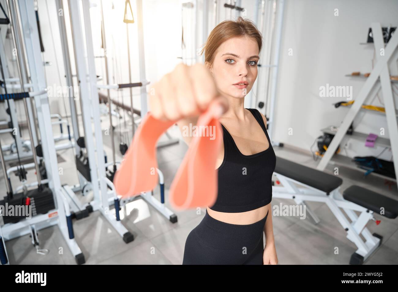 La jeune femme tient une bande élastique de fitness dans sa main Banque D'Images