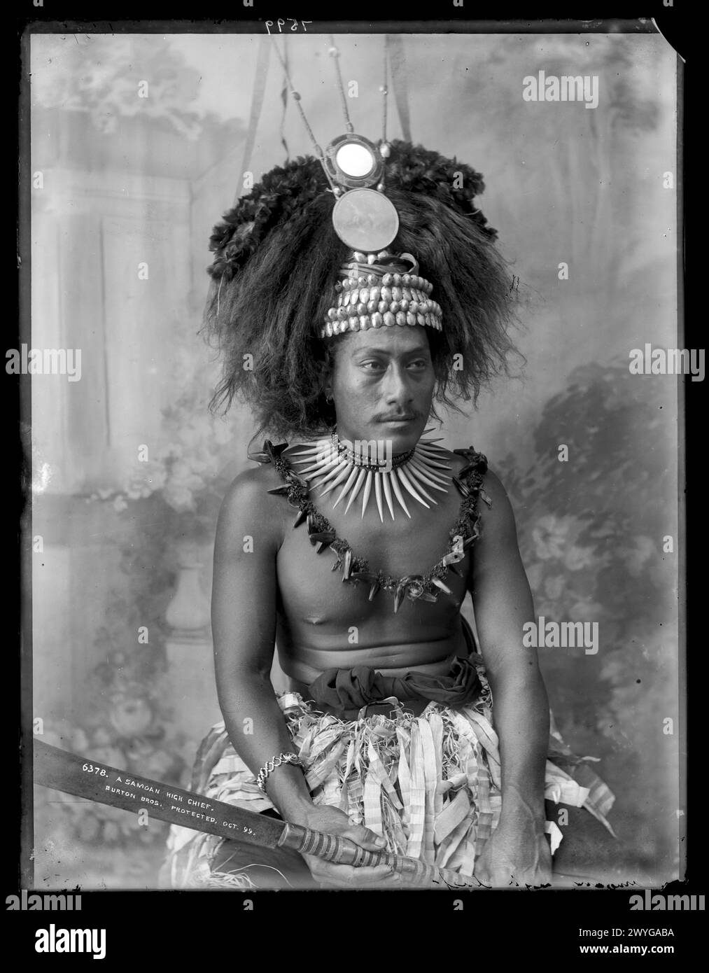 Portrait photographique d'un grand chef samoan en costume traditionnel, assis en studio Banque D'Images