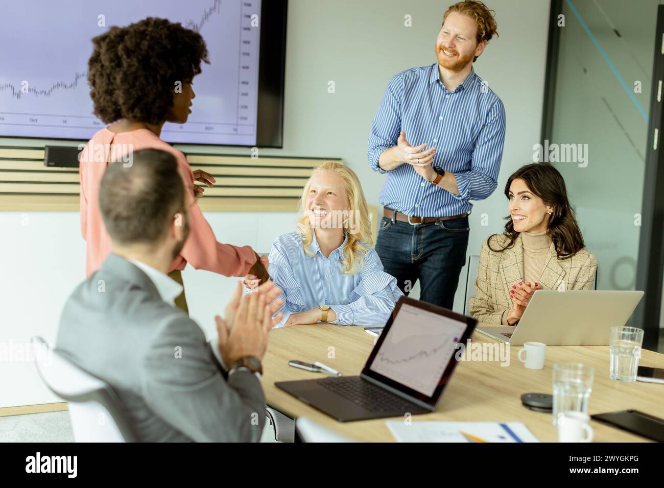 Groupe multiethnique de professionnels qui brainstorment autour d'une table de conférence dans un bureau bien éclairé. Banque D'Images